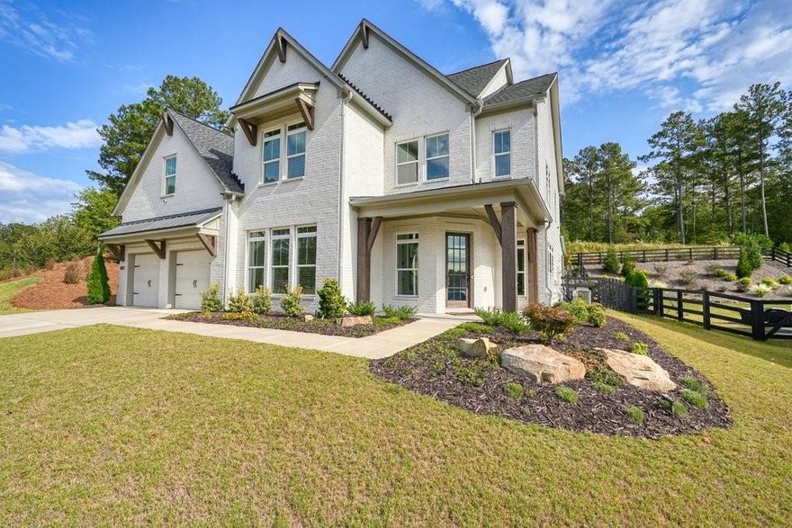 MOVE-IN READY!!  The most desired floor plan in the Holly Farm community, tucked away just beyond the Milton line in Woodstock’s desirable Cherokee County.  This home offers the perfect blend of peaceful living and sophisticated design.  UPGRADES galore in just a short time, including the outdoor grilling kitchen on the covered rear porch and scenic views of the flat fenced-in backyard. The custom outdoor kitchen has granite counters, a 5-burner True Flame grill, a True Flame griddle and refrigerator. Inside, you’ll be greeted by a grand two-story great room that makes an unforgettable first impression. The open and airy floor plan includes a private home office with double doors, a formal dining area, and a spacious eat-in kitchen with large island and top of the line appliances including a Dacor French Reveal refrigerator. Main level bedroom and full bath with an additional home office with double doors. The primary suite is a true retreat, featuring an oversized bedroom with a stunning wood-beamed ceiling and ample space for a home workspace or private lounge. The luxurious en-suite bath is thoughtfully designed with dual shower heads, a large soaking tub for ultimate relaxation, and a beautiful dual vanity set beneath a window that brings in natural light. Custom outdoor accent lighting, Nest indoor/ outdoor smart security system with indoor / outdoor cameras and ADT monitoring.  Custom draperies, built-ins and architectural beams complement the beautiful sightlines of this floorplan.  This home captures the essence of modern living with tasteful upgrades and refined finishes in a location that combines rural charm with convenience.