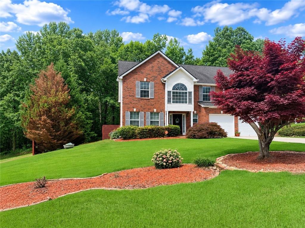 Brick exterior with white siding accents and a two-car garage