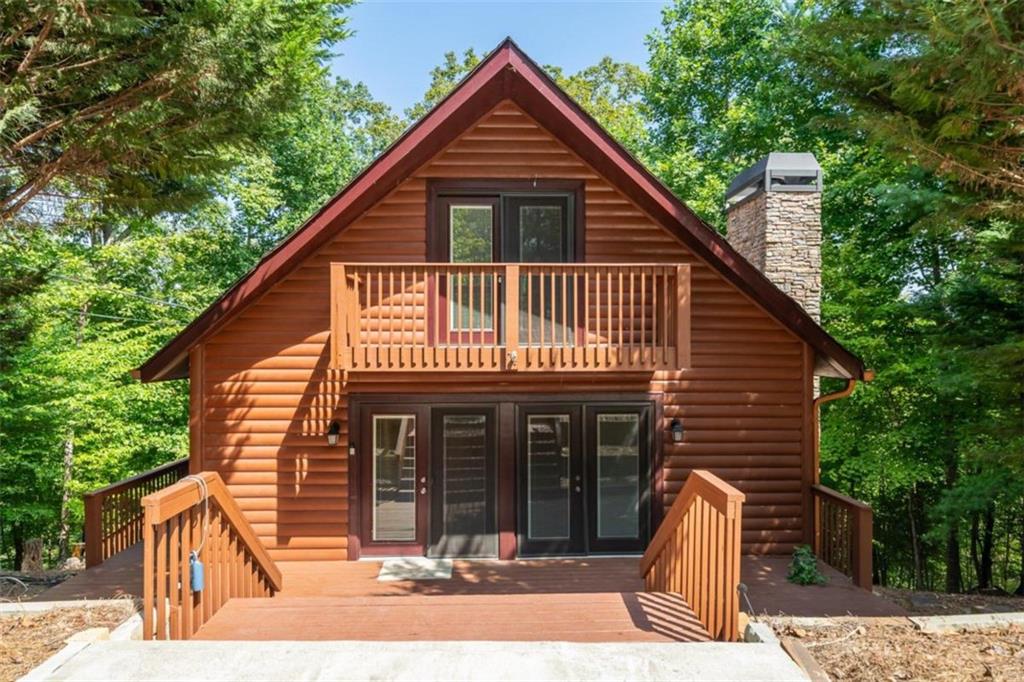 Escape to this cozy 3BR, 3BA cabin retreat, nestled on 2.3 acres across four lots. With a seasonal view of the Coosawattee River and nearby mountain ridge, this property offers a serene, treehouse-like atmosphere where you can enjoy the soothing sounds of the river year-round. The cabin features an all-wood interior with real wood floors, creating a warm and inviting ambiance. A wood-burning fireplace enhances the cozy charm. The renovated kitchen includes granite countertops, extra cabinets for storage, and a stylish stainless steel farmer's sink. The main floor has one bedroom and an updated bathroom with a walk-in tile shower, while the upper level offers two more bedrooms, one with a private balcony. The finished lower level provides a laundry area and two versatile rooms for extra bedrooms or a family recreation space.Outdoor living is just as inviting with a screened porch, and a 12 x 20 outbuilding that's spray foam insulated and wired, perfect for a workshop or storage. There's also room to add a detached garage on the additional lots. Modern conveniences include a generator, new windows and doors, a recently replaced heat pump, spray foam insulation, and Fiber Optic Internet. A termite bond offers added peace of mind, and the close-range ridge view adds to the property's picturesque setting. This cabin is ideal for those seeking a peaceful yet connected lifestyle, combining rustic charm with modern upgrades. While not a vacation rental, it's located in a short-term rental-friendly community, making it a great investment opportunity.