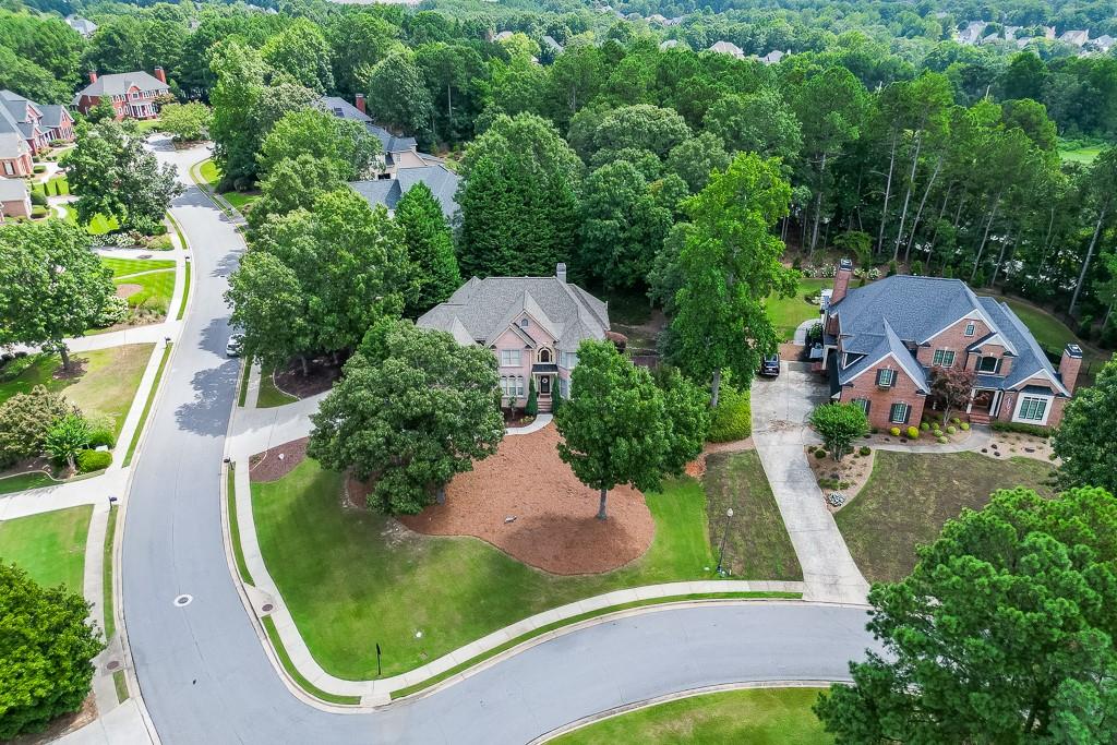 Beautiful home in the Executive style section of Town Manor in Hamilton Mill. This large open concept home has an updated kitchen looking into a spacious 2 story family room. The main floor includes a large dining room and family / flex room as well as an additional guest bedroom and full bath. Just beside the three car garage is a mud room / laundry room that carries its own full bath as well. The large master suite upstairs includes a sitting area and a spacious master bath and master closet to match. One secondary bedroom has a private bath, while the other two bedrooms share a Jack-n-Jill bath. The finished basement features a theatre room, with additional room that can be set up to fit any buyer's needs. There is also an additional bedroom and bath as well. The house sits on a large corner lot and has open free space for kids to play just across the street. Mill Creek school cluster. Amenities include two pool, 14 tennis courts, 6 pickleball courts, a soccer field and more.