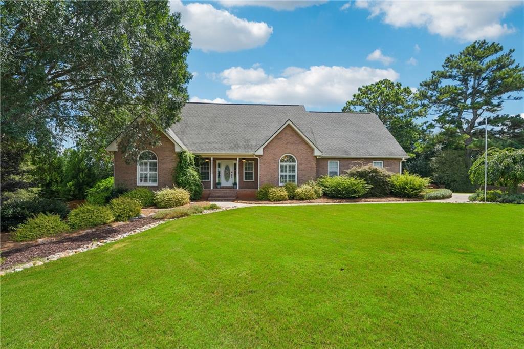 Welcome to your backyard retreat just five minutes from McDonough Square in Henry County's desirable Union Grove school district. This stunning 4-bedroom, 3-bath ranch on a full basement offers a backyard truly built for unparalleled private entertaining. The crown jewel is its custom-designed outdoor paradise: a show-stopping 23,000-gallon gunite saltwater pool with a zero-entry sun ledge, mesmerizing LED lighting, in-pool seating, and a luxurious hot tub with a cascading waterfall. As you arrive, you'll be greeted by a beautifully manicured lawn with established landscaping and a multi-zoned irrigation system, ensuring a vibrant curb appeal year-round. Take a moment to sit and relax under the custom pergola or unwind on the welcoming front porch before stepping inside. Once inside, you'll immediately notice beautiful farmhouse-style distressed hardwood floors throughout the upper level. All three spacious bedrooms on the main level provide ample comfort, while the updated bathrooms boast top-notch custom tile work. The primary shower, with its zero-entry design, dual shower heads, and built-in bench, is thoughtfully crafted for both luxury and accessibility. The living room transforms into your private theater room when the elegant barn doors, adorning the foyer entrance, are closed. A cozy gas fireplace, complete with gas logs, adds warmth and ambiance. The kitchen features granite countertops, stainless steel appliances, and convenient under-cabinet lighting. For more formal occasions, the dining room offers ample space, easily accommodating a baby grand piano or your guitar collection, truly adapting to your lifestyle. Your laundry room is complete with custom cabinetry and a pantry, just steps from the kitchen, and can be discreetly closed off with a sleek sliding glass pocket door - keeping laundry out of sight! Even the garage has been elevated, with a professionally applied epoxy floor and custom wall treatments. As you make your way into the basement, you'll find its own separate HVAC system. It also features a designated workshop area. Outside, the back deck, crafted from exquisite Brazilian IPE hardwood, is truly extraordinary. It's your private oasis. The deck below offers a covered dry zone with a built-in bar, perfectly poised for hosting memorable parties. Just steps away lies your custom-crafted gunite saltwater pool, featuring a zero-entry sun ledge, bubbling LED lights, and plentiful in-pool seating areas with umbrella mounts. Complete with a hot tub and a cascading waterfall, this pool is an absolute showstopper. The custom pump house pavilion, with its dual sliding barn doors and a grand chandelier, matches the adjacent custom cedar pergola, complete with a natural gas fire pit. The pool itself is as smart as it is stunning, including a new variable speed pump, filter housing valve, saltwater cell, and LED lights, for effortless enjoyment. Additional highlights include: Tankless water heater, Laundry with custom cabinetry and pantry, and a 10 x 10 Outdoor Shed to store lawn equipment. Whether you're hosting poolside parties or enjoying a peaceful evening under the stars, this property blends luxury, comfort, and lifestyle like no other.