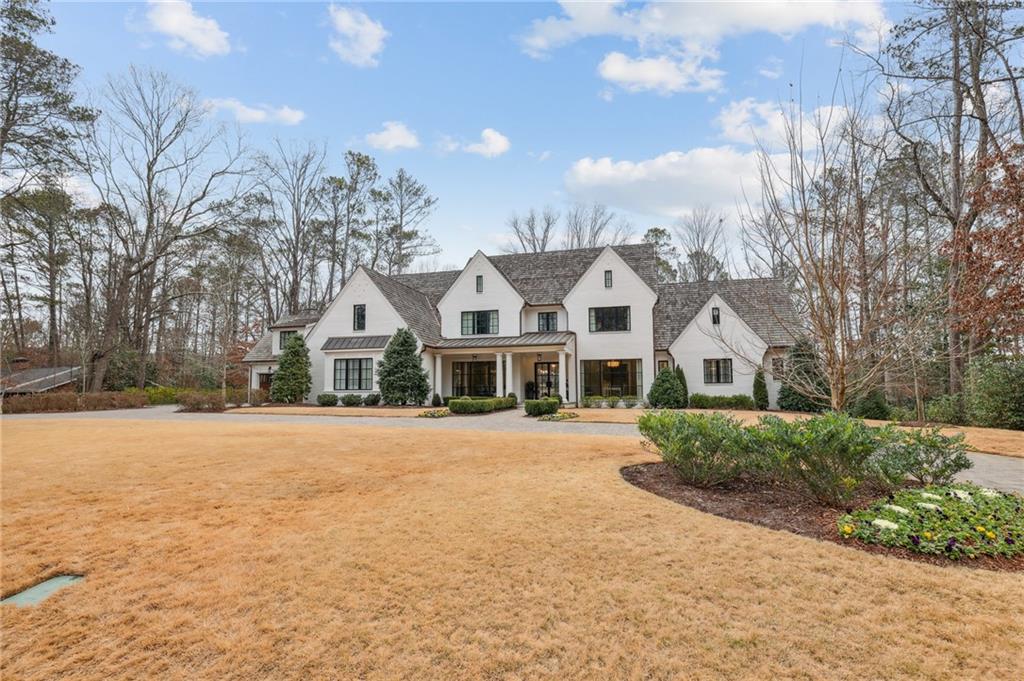 Stunning painted brick home with cedar shake roof and copper gutters. Primary on the main with elevator to three floors. A large open floor plan with folding glass walls/ accordion doors in the great room and keeping create a seamless indoor and outdoor living space with a motorized screen between the blue stone-covered porch and grill porch. There is another screened porch with a fireplace off the breakfast room. The chef's kitchen has marble countertops, custom cabinets, a walk-in pantry,  Wolf/Subzero appliances, and a fireside-keeping room. The appliances include a steam oven, a dual fuel range with double ovens, a single wall oven, a Separate refrigerator and freezer, Built-in coffee, under-counter refrigerator drawers, Wine refrigerators,  and an Ice machine—Bulter's pantry. The primary suite on the main has a morning bar, a luxurious primary bathroom with heated floors, a double vanity, a soaking tub, a sizeable curbless entry shower, heated floors, two water closets with vanities,  and two custom walk-in closets. Upstairs are five en-suite bedrooms with walk closets, a loft, and a Bonus/flex room. The recently completed terrace level has a fabulous bar with refrigerator drawers, Two wine refrigerators(125 Bottles a piece), a Dishwasher drawer, and an Ice maker. Large rec room and game room. Exercise room with cork floors, refrigerator of cold drinks, and towels. The terrace level leads onto a blue-covered patio and 18"X40' pool and spa. The entertaining continues with a large poolside TV for watching sports while relaxing in the pool or sitting by the rectangular fire pit. Other features include three laundries, a mudroom, front and rear stairs, foam insulation, a horseshoe driveway, and a whole house generator, to name a few.