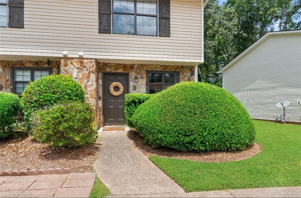 Welcome to this inviting end-unit townhome just off Lake Lanier offering a perfect blend of privacy, comfort, and convenience. As part of a quiet, well-kept community, you’ll have access to two private docks ideal for swimming, fishing, or enjoying life by the water. Just behind the home, you can walk to Holly Park, a hidden gem that leads to a scenic riverbank, offering a peaceful escape anytime you want! Nearby Paul Park has a pavilion, picnic tables, and more. This well maintained townhome boasts stacked stone exterior accents and an attached driveway for flexible parking. Inside, you’ll find a floor-to-ceiling stacked stone fireplace that serves as a stunning focal point in the heart of the home, which offers a blank canvas to design a space that fits your lifestyle from cozy and relaxed to modern and vibrant. The kitchen is equipped with updated stainless steel appliances, pantry, and a fresh clean feel ready for everyday living or entertaining guests. Upstairs, enjoy two spacious en-suites, including a primary suite at the back of the home complete with it's own private deck. Ideal for roommates, guests, or multi-generational living, each with plenty of privacy and natural light. Step outside to your covered back patio overlooking a backyard with peaceful wooded views, creating a perfect retreat for morning coffee or evening relaxation. Located just outside the hustle and bustle, this home offers the perfect balance of tranquility and convenience while close to grocery stores, shopping, dining, healthcare, reputable schools, and major highways for an easy commute. Don’t miss the opportunity to enjoy low-maintenance living in a scenic and accessible location!