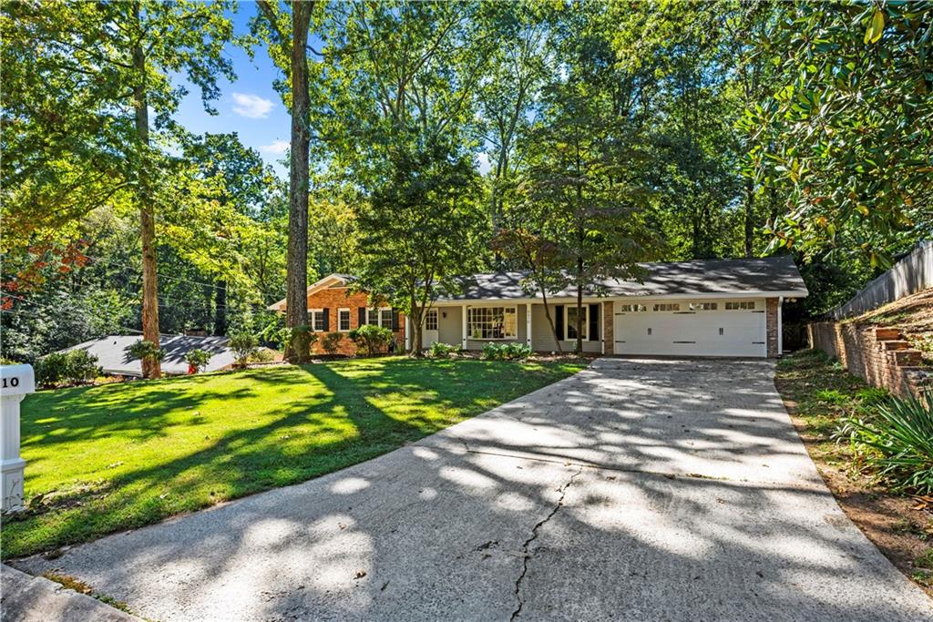 Set on nearly half an acre in the heart of Sandy Springs, this 2,900-square-foot ranch with a finished terrace level offers an exceptional blend of space, function, and location. The main level spans approximately 1,900 square feet and features an open, light-filled layout with a large living and dining area that flows effortlessly into an inviting kitchen with bay-window views of the backyard and a casual breakfast nook. Three well-sized bedrooms and two full baths provide comfortable accommodations, with thoughtful details and natural light throughout. The fully finished terrace level adds another 1,000 square feet of impressive living space, complete with new luxury vinyl flooring, fresh paint, and a flexible open layout ideal for entertaining, a media room, or recreation. A spacious office with windows, a private guest suite with a full bath, and an additional exercise or hobby room with exterior access make this level as functional as it is inviting. Outside, the home’s curb appeal is enhanced by a recently added two-car garage, a wide front yard, and a private backyard with a generous deck perfect for outdoor dining or relaxation. Located in one of Sandy Springs’ most desirable and walkable neighborhoods, this property offers effortless access to nearby shops, restaurants, and parks — the ideal balance of space, setting, and convenience.