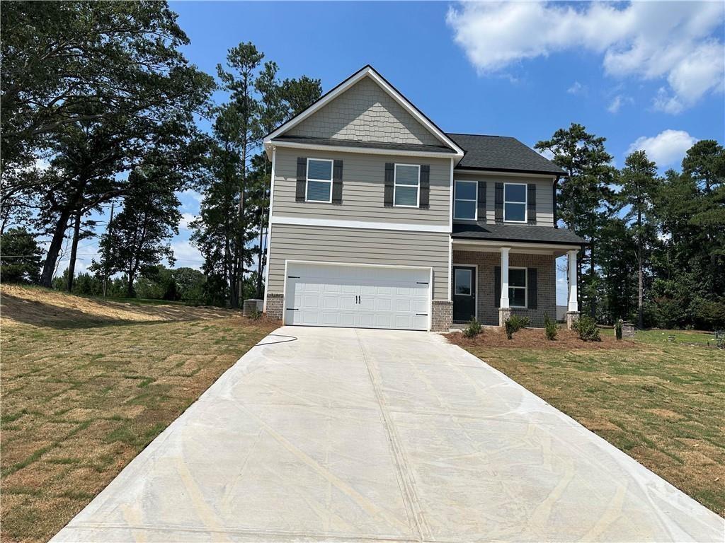 Priced to sell, lowest cost new construction on a basement in Paulding County! Our incredibly popular Hudson Plan, located in the Paces Lakes Subdivision with NO HOA and full basement! This Hudson floor plan features 3 bedrooms, 2.5 bathrooms, and a 2-car garage. View of lake off back porch! The home boasts an open concept design, making it perfect for family gatherings, with plenty of natural sunlight illuminating the space. Among the included features are a spacious open kitchen with an island, which offers open views to the separate dining room and family room. Additional highlights include soft-close cabinets, granite countertops in the kitchen and bathrooms, and stainless steel appliances, including a microwave, dishwasher, and electric free-standing range. The main level has LVP flooring throughout, while the bedrooms are carpeted. On the main level, there's a guest bedroom with an adjacent full bathroom. The second level showcases a generously sized primary bedroom with a spacious walk-in closet. The primary bathroom features granite countertops, a dual vanity, and a roomy tile shower. You will also find two additional nicely sized bedrooms and another full bathroom on the second level. Don't miss out on this opportunity! We are offering great buyer incentives with the use of an approved lender. "Please note that the photos are not of the actual property, they are stock photos representing a Rose Plan for illustration purposes only."