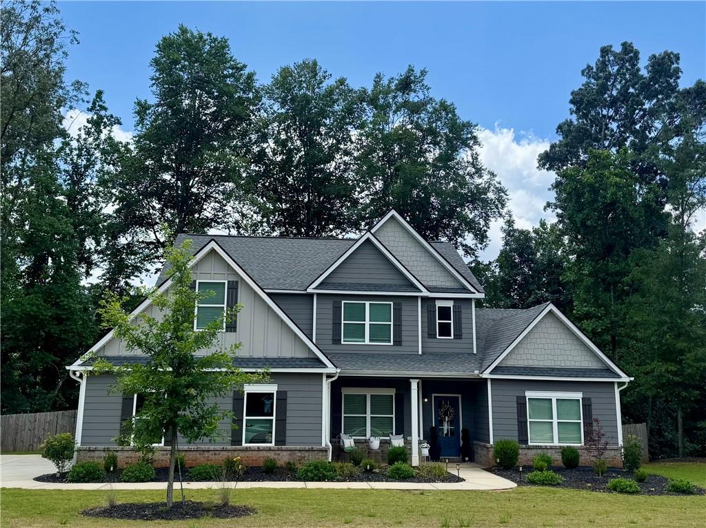 This stunning 4-bedroom, 3.5-bath home sits on over half an acre, corner lot with a large, level driveway. The open-concept layout features a bright great room with a board and batten accent wall, brick fireplace, and tons of natural light, flowing into a chef’s kitchen with stainless steel appliances, a large island, and granite countertops. You'll love the bonus room off of the kitchen perfect for an office or convert to your dream scullery that will be sure to impress your guests. The main-level primary suite boasts a spa-like bath, dual vanities, a soaking tub, and a custom walk-in closet. Upstairs, you'll find three additional bedrooms, 2 full bath, and a versatile loft area perfect for play or media room. Freshly painted with custom updates, a formal dining room, fenced backyard, and ample storage, this home is minutes from Lake Lanier, shopping, and dining in Flowery Branch. A must-see!