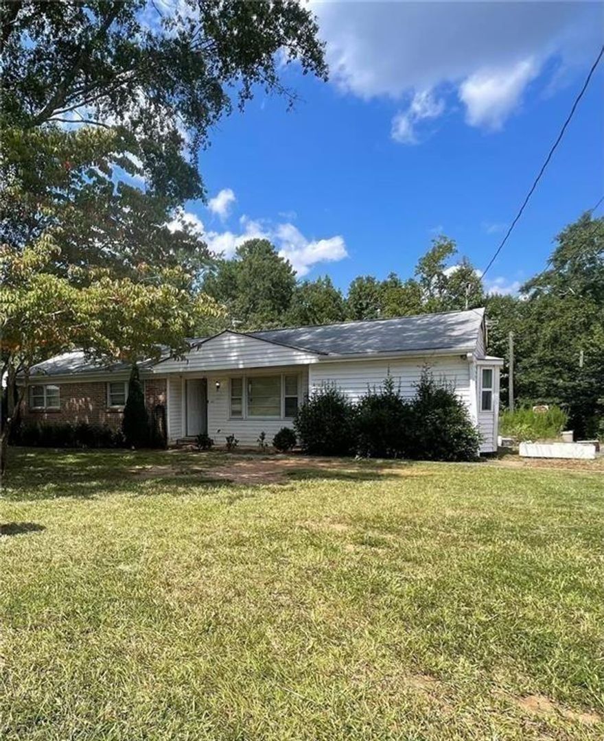 This 3-bedroom, 2-bath home is full of potential and set on a spacious 1.577-acre-lot, an acre larger than neighboring properties. Whether you're looking for a peaceful place to call home or a great investment opportunity, this property has the space and features to make it truly special. Recent updates include a new roof, new HVAC system, and new updated plumbing, giving you a strong head start. The home has great bones and is ready for someone to bring it to life. Property includes outbuildings and a large workshop with it's own HVAC and plumbing, perfect for storage, hobbies, or future projects. A creek runs along the back of the lot, adding natural charm. With room to expand and a unique setting, this home is a rare find with endless possibilities.