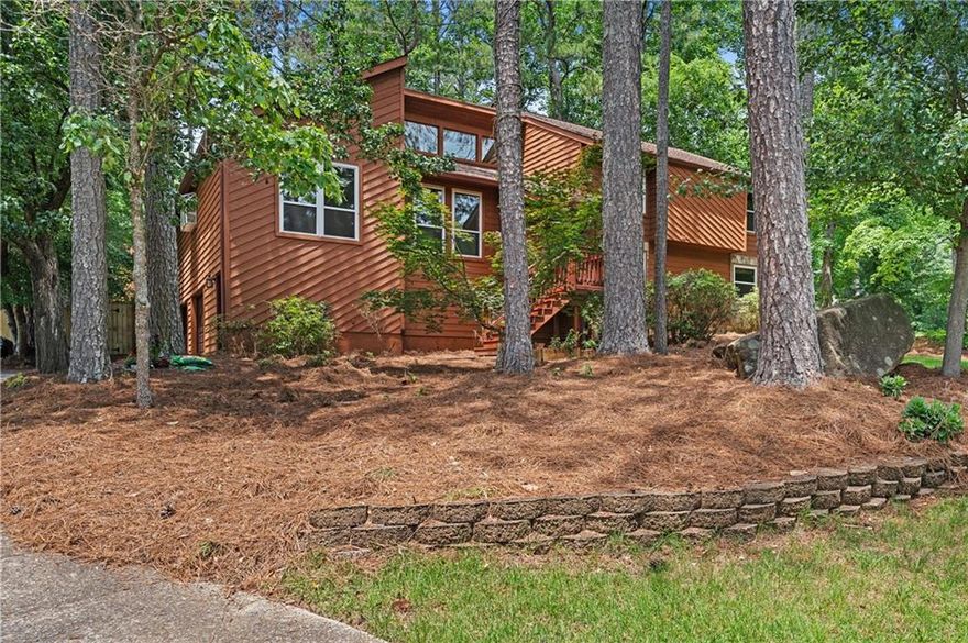 Enjoy a desirable open concept home w/beautiful light filled, highly functional rooms and massive fenced backyard!  A welcoming entry joins a huge fireside great room w/fresh paint, gorgeous hardwoods, vaulted ceilings and new windows and sliding glass doors.  This area leads to the family-sized dining area w/beamed accents+ceilng fans. Home  cooks will  enjoy the renovated kitchen w/fabulous tongue and groove  ceiling, tons of storage in full height cabinetry, skylights, cooking island w/gas cooktop, huge pantry and eat-in kitchen area. Kitchen opens to coveted screened back porch overlooking the grilling deck and backyard.  Journey upstairs to the lovely primary bedroom w/vaulted ceiling, oversized walk-in closet,  and newer carpet. The charming renovated  master bath has his/her sinks,  A+ countertops,  soaking jacuzzi tub, newer lighting/tile and walk-In shower.  There are 2 great-sized upper level bedrooms + shared bath. Convenient upstairs laundry area.

Venture downstairs to enjoy handsome tiled  drop off mudroom at the garage  entry. Full-sized terrace level boasts another full bedroom/office/play space+full renovated bath. Enjoy game day in this  paneled entertainment area w/ full bar/fridge area and access to lower deck/exterior.  PLUS, the garage is huge offering multi car parking + handyman’s favorite workshop area and full-room storage.
The home sits on a wonderful corner lot w/greenspace/woods and walkability.  Well maintained systems, new windows and glass doors except lower level, fresh paint,  newer water  heater+ carpet, Wonderful location, school district, ease to shopping and  interstates!  Swim/tennis is accessed via neighboring subdivisions or East Cobb Swim/Tennis.