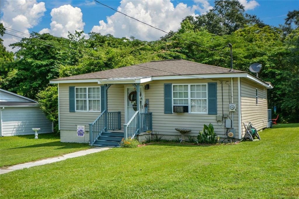 Give Budget a Break and Eyes a Treat! If you are just starting out or downsizing, this jewel offers great options for both. Be impressed by curb appeal, a light-filled living room, a sizeable country kitchen, focusing on practicality and charm, plus an adjoining laundry room with ample space for pantry expansion. The bath has been updated with a large, step-in shower and the carpet and roof are nearly new. Savor a morning cup of coffee or an open-air lunch on your over-sized deck, and the detached building is ideal for storage, lawn equipment or a potting shed. Summer magic is just minutes away, featuring the enjoyment of a quaint historic district, boutiques shops, trendy restaurants, events and festivals. Proximity to grocery stores, hospital and Interstate-20 simply adds to the benefits.