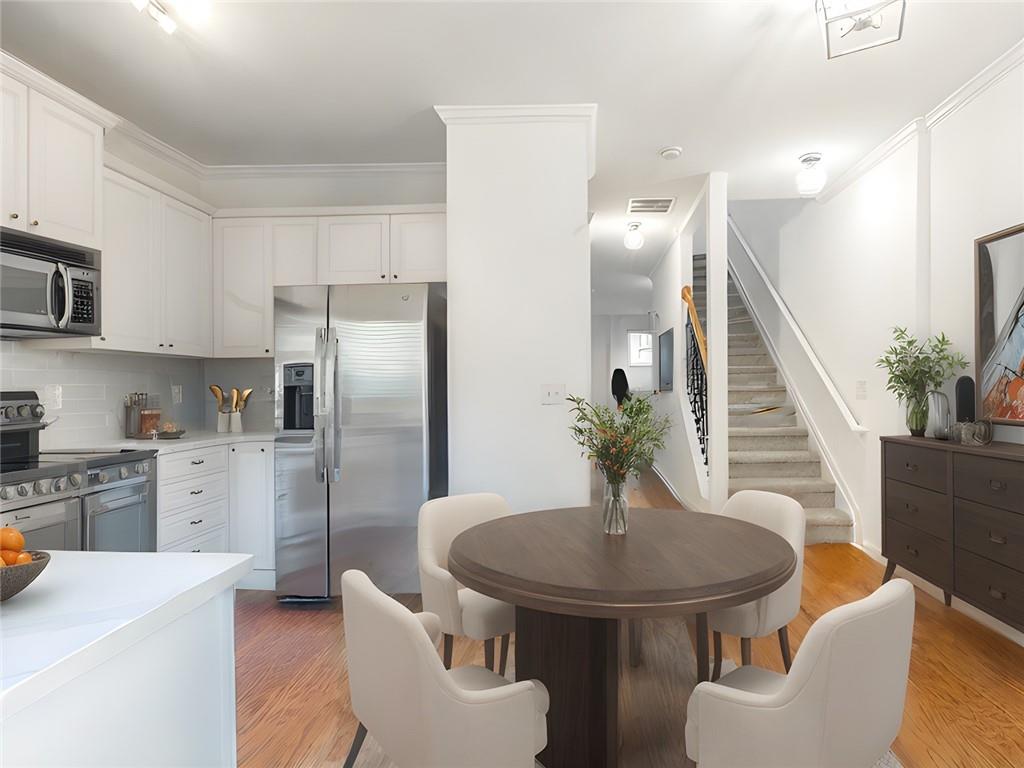 A Must See - The BEST VALUE in Liberty Park! The community's most desirable floor plan that just completed top-to-bottom renovations, this beautiful townhouse in the sought-after Liberty Park community in Atlanta's Upper Westside is ready to impress! The updated kitchen features sleek new quartz countertops, a stylish backsplash, a modern faucet, and freshly painted cabinets. Enjoy brand-new lighting fixtures throughout and repainted interior. The bathrooms have been upgraded with brand-new vanities, and new carpeting is installed throughout. Spread over three spacious floors, this home is flooded with natural light and features both a front balcony and a private back deck overlooking peaceful green space. The open-concept main level is ideal for entertaining, with multiple living and dining areas. The lower level, with a full bathroom, offers flexibility as a third bedroom, office, or guest suite, complete with direct access to the attached one-car garage. Upstairs, the primary suite and a secondary bedroom, each with their own private bathrooms, provide a serene retreat. Located in vibrant West Midtown, with easy access to I-75, Buckhead, and Midtown, this townhouse is tucked away behind a secured guard gate in a community with fantastic amenities, including a pool and dog park. Walk to nearby restaurants, shops, parks and all the exciting offerings of West Midtown. With top schools and entertainment options close by, this townhome has it all!