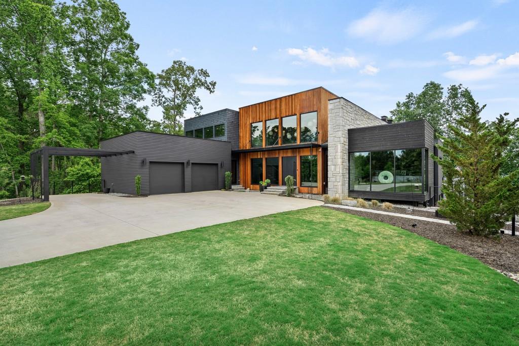 EXQUISITE LAKE LANIER HOME. This CUSTOM beauty boasts incredible lake views, a double slip boat dock on deep water, a striking open floor plan, 5 bedrooms, 5 bathrooms, 2 half bathrooms, 6 bed bunk room, salt water swimming pool, 2 roof top lounge areas, serving kitchen-bar that opens to the pool, 2 separate attached garages, workshop, sauna and so much more.. This distinctive newer construction home is truly one of a kind and a rare find on Lake Lanier!