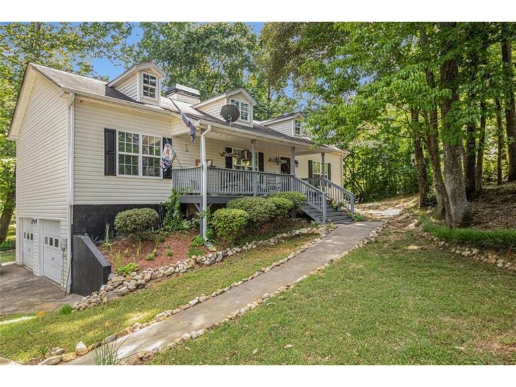 This home offers eclectic charm with a primary suite on the main level, providing an easy-living lifestyle in a private cul-de-sac with no neighbors in sight. With 4 bedrooms and 3 bathrooms, this home provides ample space for the family. The first floor boasts 18-foot ceilings and includes 3 bedrooms and 2 full bathrooms. The basement features a finished family room, an additional bedroom, a full bathroom, and an office space — perfect for privacy or work-from-home needs.
Spanning a generous living space on over a half-acre lot, this home is located near the best of Temple, GA. Enjoy the peaceful outdoors from the deck overlooking a small stream that flows through the property, offering tranquility and nature at your doorstep. Relax on the inviting rocking chair front porch while enjoying the quiet surroundings.
Please note that this home features all-electric appliances (there is no gas service), and the fireplace is fueled by wooden logs. The stove and refrigerator are not included with the sale but may be available for purchase.
With its vaulted ceilings, spacious rooms, and beautiful outdoor setting, this home is a must-see. It won’t last long!