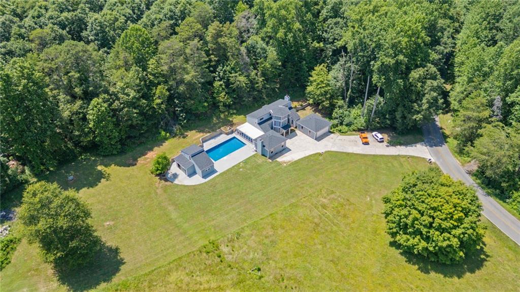 One-of-a-Kind Mini Estate on 3.7 Acres! Ready to trade cookie-cutter for character? Welcome to 6592 Rufus Bryant Road—a playful contemporary hideaway with endless potential and personality-PLUS! Tucked down a peaceful country road, this sprawling 3-bedroom, 2.5-bathroom fixer-upper also comes with a 1-bedroom, 1 bathroom detached GUEST HOUSE! Perfect for hosting family, setting up your art or yoga studio, or turning into a short-term rental for instant income potential. The guest house adds incredible versatility and value. Just minutes from charming downtown Dahlonega, Lake Lanier, Gainesville, and all the mountain adventures your weekend bucket list can handle, this property is a hidden gem begging for your personal touch. Step inside the expansive home and let your imagination run wild. Vaulted ceilings and tons of natural light offer an airy canvas, ready to be transformed. The family room is anchored by a cozy fireplace—one of three in this unique home. Imagine chilly evenings curled up by the fire, planning your next home improvement adventure. Love hosting big gatherings? You’ll be thrilled by the oversized dining area, flowing effortlessly into a huge bonus room with yet another fireplace—perfect as a main-level owner's suite, epic game room, or creative studio. But wait, there’s more: climb the spiral staircase (yes, really!) up to your whimsical lookout loft. Whether it’s a reading nook, a stargazing observatory, or the ultimate secret fort, this loft promises quirky charm and endless inspiration. Outside, your very own private resort awaits. Splash into summer fun immediately—the massive in-ground pool features a brand-new liner, meaning pool parties, BBQs, and lazy Sundays lounging with friends start NOW. With 3.7 acres of flat, usable land zoned Agricultural, your dreams of homesteading, gardening, or even keeping horses and goats can come true. Parking your RV, boat, or fleet of ATVs? Absolutely no problem here—there’s room for everything and no HOA to slow you down. Priced attractively and sold as-is, this one-of-a-kind property invites you to bring your tool belt, your Pinterest inspiration boards, and your sense of adventure. It’s quirky, it’s cool, and it’s ready to become your masterpiece. Ready to write the next amazing chapter at 6592 Rufus Bryant Road? Your dream project awaits—just bring your swimsuit and imagination!