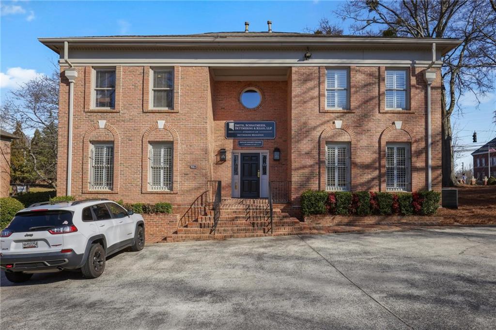 Exceptional 2-Story Brick Office Building in Prime Central Marietta Location
This stately brick office building offers a versatile layout, perfect for accommodating multiple businesses. Featuring 8 spacious offices, welcoming reception areas, conference rooms, ample storage, and well-appointed bathrooms on both levels, this property provides everything you need for a productive work environment. A shared kitchen adds to the convenience, making this an ideal space for professional growth.
The property boasts a generous parking lot with 25 spaces and easy access from two sides, ensuring convenience for clients and staff alike. The building can be accessed through a well-designed back entrance with a two-story foyer, or via an accessible front entrance, complete with a brick ramp and sidewalk.
Upon entering through the back, you’ll find a central hallway leading to a half bath and the staircase to the second floor. To the right, you’ll discover a bright and airy conference room and two large offices with 10-foot ceilings, hardwood floors, and expansive windows that flood the space with natural light. To the left, you'll find a comfortable waiting room, two administrative areas, a fully-equipped break room, and two additional offices—one featuring its own half bath.
Upstairs, the second floor features separate men’s and women’s bathrooms located in the hallway. To the right, a large reception area is complemented by a beautifully crafted, semi-circular wooden desk, flanked by two spacious offices. A smaller office, ideal for records or storage, completes this section. To the left of the staircase, you'll find a similar layout with a reception area, two large offices, and an additional file room.
With its thoughtful design and prime location, this property offers an outstanding opportunity for businesses seeking a functional, professional space in the heart of Marietta.
