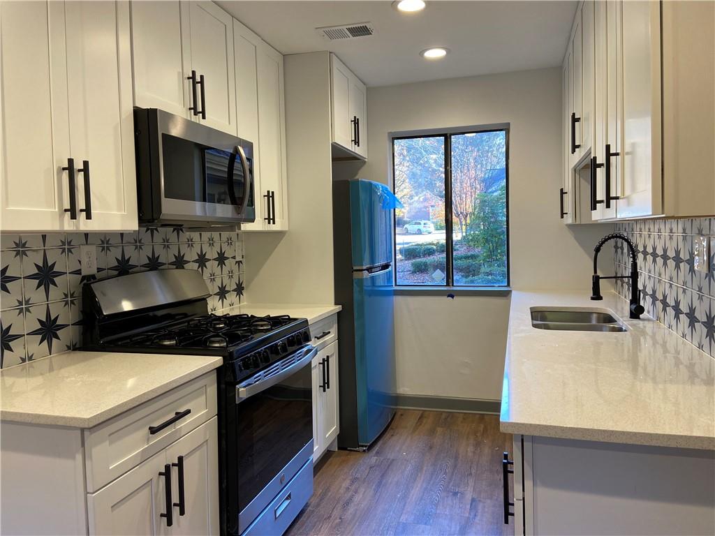 Welcome to this captivating 2-bedroom, 1-bath single-level townhouse in the highly sought-after Country Place neighborhood! This beautifully remodeled gem offers a delightful living experience with a blend of modern style and classic charm. Revel in the warmth of gleaming hardwood floors that flow seamlessly throughout the entire home. The kitchen boasts a designer backsplash and hardware, elevating your culinary space to a new level of elegance. Enjoy the convenience of sleek stainless steel appliances, including a refrigerator and washer/dryer, which come included with the rental. Water/Sewer/Trash and exterior maintenance included!! Experience the ambiance of updated lighting fixtures that enhance the overall aesthetics of the interior, creating a welcoming and cozy atmosphere. Step onto the patio in the backyard, perfect for outdoor relaxation and entertaining. This private outdoor space is an extension of your living area and provides a serene retreat. You'll find yourself in an unbeatable location! Just minutes away from Avalon and GA 400, you'll have easy access to shopping, dining, and major highways for a convenient lifestyle. Located in a stellar school district, this property ensures access to excellent educational opportunities for your family. Rent includes water, sewer, and lawn care! Don't miss out on this exceptional opportunity to live in a meticulously remodeled townhouse in one of the most desirable communities in the area. Act quickly, as this property won't stay on the market for long!
