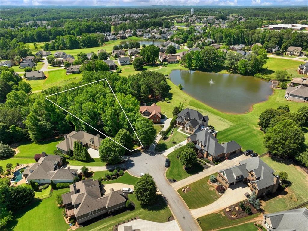 A Rare Opportunity in Traditions of Braselton! Build your private retreat surrounded by nature. Tucked into a quiet cul-de-sac and backing to Hole 6 of the private Traditions golf course, this .56-acre wooded lot offers a unique blend of privacy, natural beauty, and prime location. Just steps from Baker Pond, the setting feels like a private nature preserve complete with mature hardwoods, serene views, and even a natural spring head tucked into the landscape. This property is buildable and ready for development. A county-approved variance allows for building closer to the spring head than typically permitted, giving you the flexibility to design your custom home while preserving the surrounding beauty. Whether you’re looking to build a quiet retreat or expand your footprint from the neighboring property available for purchase (70 Baker Pond Ct), this lot offers exceptional potential in one of Jefferson’s most sought-after communities. Enjoy all the lifestyle perks of Traditions of Braselton, including a private golf course, on-site restaurant (Twenty7), resort-style pool, tennis and pickleball courts, miles of walking trails, and private golf cart access to Gum Springs Elementary School, West Jackson Middle and Gum Springs Park. One of the few remaining lots of this size and setting, don’t miss the chance to create your dream in the heart of Traditions.