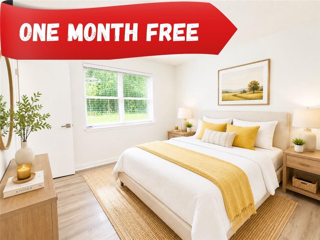 Bedroom featuring wood-finish flooring, a double window with blinds, and white walls