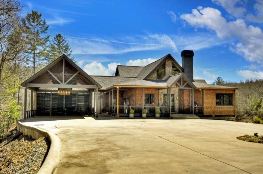 Calling all outdoor enthusiasts! Welcome to your own contemporary rustic compound sitting on sixty +/- acres and adjoining US National Forest! With modern luxuries and mountain charm, this sprawling lodge is complete with four bedroom suites, two additional bunk areas, a large office overlooking the lush rolling meadow, and gorgeous Carrera marble bathroom ensuites. Sleek accents combine with painted tongue and groove walls and ceilings, rough sawn cabinetry, and walls of glass to create the perfect blend of modern and rustic finishes. Main level living room is centered around large stone F/P, gourmet kitchen, butler's pantry and stunning eat-in island. Off the main, find an 1,110 sq. ft. bespoke party porch w/ 24' rooflines, large masonry F/P, and gourmet outdoor kitchen. Terrace level den opens up to large stone patio and heated pool w/ jacuzzi overlooking lush meadow, stocked pond, and complete privacy. Full entertainer's bar is accessed from pool deck w/ full drink cooler and pool house kitchen. At top of property, find an original hunter's blind turned outdoor party pavilion with 180 degree mountain views, massive fire pit, and half bath. Also includes an unfinished 4,000 sq. ft. barn w/ power and plumbing, two small pole barns, and a three bay car barn. Fully gated, equipped w/ a whole house generator and with a roaring creek that runs throughout the property and with numerous potential home sites, this would make for the perfect mountain retreat, investor's project, or rental investment!