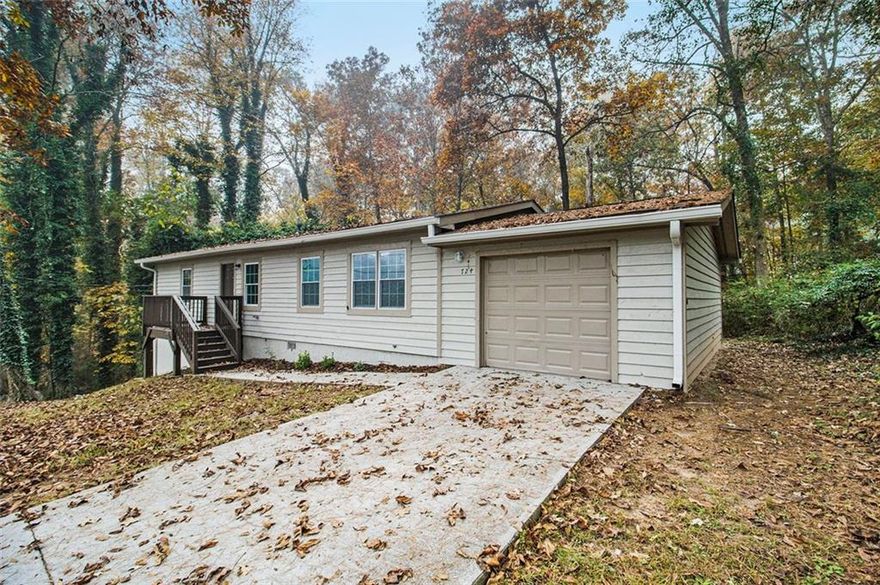 Here's the truth nobody wants to tell you: While you're waiting for the "perfect" home to magically appear at the "perfect" price, someone else just bought this one. At $215,000, this property solves the exact problem keeping you up at night, finding something genuinely affordable that doesn't require a contractor on speed dial or a two-hour commute to anywhere that matters. What you're looking at here is 1,224 square feet of genuinely practical living space, where someone clearly understood that not every home needs to shout to make its point. The taupe cedar siding blends naturally with the wooded surroundings, while that elevated deck out back promises morning coffee sessions accompanied by nothing but birdsong and rustling leaves. Step inside and you'll find what sensible really looks like. Wood-look tile flooring flows throughout, giving you the warmth of hardwood with the durability that handles real life without complaint. The living space opens directly to the dining area and kitchen, creating that natural circulation where conversations drift from room to room without missing a beat. Those cherry-toned cabinets? They're paired with gleaming granite countertops and stainless appliances including a gas range for anyone who takes cooking seriously. Over-the-range microwave saves counter space, dishwasher means less time at the sink. The primary bedroom sits privately positioned with its own ensuite bath, while two additional bedrooms share the second full bath, both featuring crisp white fixtures and clean finishes that make mornings feel less like a chore. Fresh paint in calming neutrals creates that blank canvas where your furniture and life fill in the personality. Now step outside. That deck overlooks a backyard sloping gently toward the tree line, where nature provides all the privacy fence you'd ever need. The lot drinks in fallen leaves, creating that quintessential autumn scene that reminds you why people choose Lithonia over cramped intown living. Room for a fire pit, room for dogs to roam, room to actually breathe. Real estate is about location, and The Trace delivers exactly what east DeKalb buyers want. You're less than two miles to Covington Highway's retail corridor with Kroger, Walmart, daily needs handled. Stone Mountain Park sits five minutes north for weekend trail runs or lazy lake days. I-20 is three miles south for the westbound commute, Stonecrest Mall practically next door. Arabia Mountain's hiking trails? Ten minutes. Downtown Decatur? Fifteen on a good day. Yet back here on The Trace, tucked into this established neighborhood, you'd never know civilization was so close. This is move-in ready territory with no hidden surprises, no deferred maintenance eating your savings. Let's talk about what this actually buys you elsewhere. A condo with HOA fees that never stop climbing? A fixer-upper needing another $50,000 before it's livable? Here, you get the complete package with garage, private lot, established neighborhood, actual trees instead of parking lots. The kind of straightforward value becoming extinct in metro Atlanta. As The Trace continues attracting buyers seeking that sweet spot between value and convenience, early movers secure the best positions. This isn't about trendy barn doors, it's about solid bones, smart location, and a price that makes your mortgage payment look like yesterday's rent. Move fast because someone's already scheduling their showing while you're still reading this. Call your agent today for your private tour. Serious, pre-qualified buyers only.