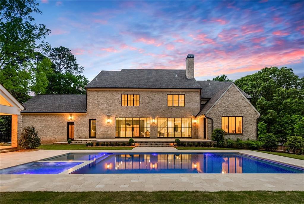 Situated in the heart of Sandy Springs with a pool/spa, welcome to this 6-bedroom, 5-bathroom, 2-half bathroom, 4-car garage, gated timeless home boasting luxury living at its finest. Accentuated with the finest materials and finishes throughout, you are welcomed with elevated 10ft ceilings, bright natural light, and an open floor plan that allows for a seamless flow between all living spaces. This grand gourmet chef's kitchen is an entertainer's dream! An expansive waterfall quartz island in the center of the room provides ample seating and counter-space. The professional-grade appliances, including a stainless steel oven / six burner cooktop, and side-by-side panel refrigerator, ensure that the chef at heart can create top-notch meals with ease. The kitchen opens directly to the spacious family room with a gorgeous stucco fireplace, custom built-in shelving, striking French glass doors and windows that open to the spacious backyard oasis creating the quintessential indoor/outdoor poolside living experience. Additionally, the main level includes a formal dining room with custom accent wall, wet bar, butler’s pantry, mud room, laundry room and the primary suite. The luxurious primary suite is the perfect retreat for any homeowner, complete with a sitting area, office, and designer light fixtures. The spa-like bathroom features a freestanding soaking tub set in a soothing atmosphere, his and her vanities, a stunning marble shower with a rain shower head, and an extensive closet ready for customization. With its luxury amenities and tranquil atmosphere, this suite is the perfect place to relax and unwind after a long day. The second floor of this home boasts five spacious bedrooms, each one with plenty of closet space, and four full bathrooms. There is also a second entertainment area, with plenty of room for comfortable oversized seating, a pool table, or anything else your heart desires. This space is perfect for entertaining family and friends. The expansive backyard is an entertainer's dream, with a large pool and spa, cabana with a brick fireplace and half bathroom, and mature landscaping providing lots of privacy. Conveniently located within minutes of shops and top-rated restaurants that Sandy Springs and North Buckhead have to offer.
