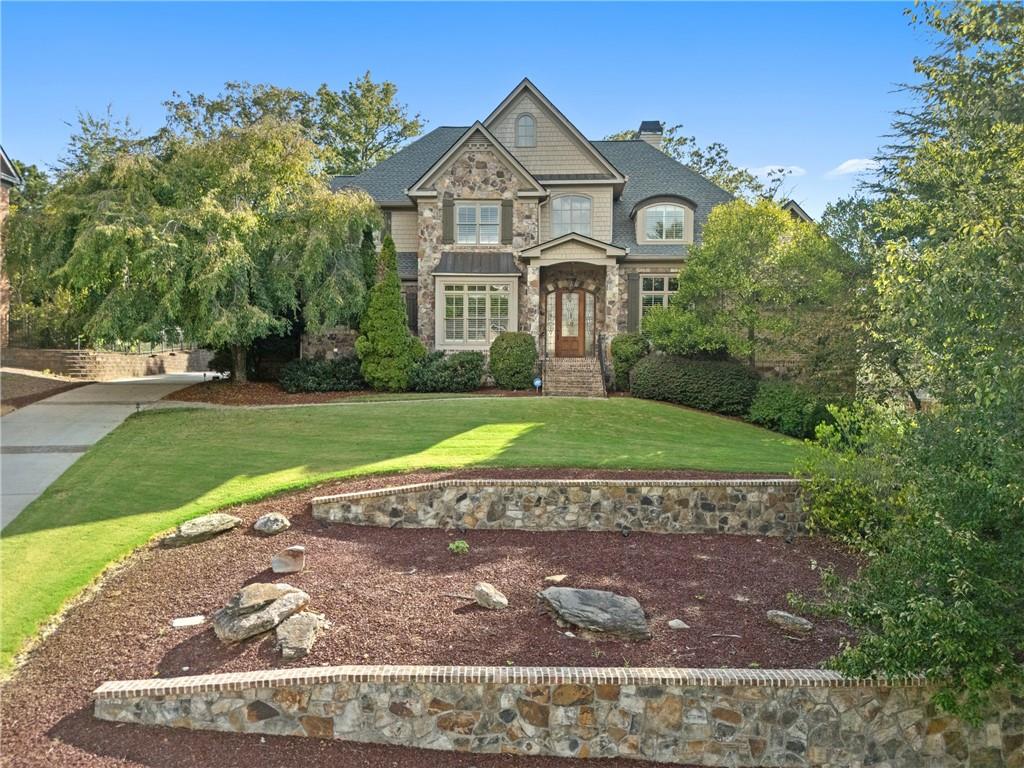 Welcome to an elevated lifestyle in the Spalding Stables Gated Community in Sandy Springs, where this beautiful four-sided brick home with a 3 car side entry garage and a master on main awaits. Step inside and discover an open and airy main level, bathed in natural light thanks to new windows and enhanced by plantation shutters, freshly sanded hardwood floors, and updated paint. The dramatic two-story foyer sets the stage for the home's refined interiors, while the chef's kitchen boasts custom cabinetry, granite counters, stainless steel appliances, a Sub-Zero refrigerator, a double oven, warming drawer, wine cooler, and a large island with a breakfast bar. This culinary haven flows seamlessly into a cozy keeping room and a spacious family room, both featuring fireplaces and access to a beautifully landscaped backyard with a pool, spa, and grilling area, creating a private oasis perfect for casual gatherings and grand entertaining. The main level also offers an oversized owner's suite, providing a luxurious sanctuary with direct access to the backyard, including a customized walk-in closet with built-in shelving and drawers, and a spacious en-suite bathroom. A formal dining room, complete with wainscoting and a tray ceiling, is perfect for hosting elegant dinners, while a convenient butler’s pantry for effortless entertaining, a wet bar, walk-in pantry, mudroom, laundry room, and a private large study add functionality. Upstairs, four generously sized bedrooms offer comfortable accommodations, with two bedrooms featuring private bathrooms and the remaining two sharing a Jack and Jill bathroom, along with a versatile flex room that can adapt to your needs, whether it's an office, playroom, or media room. The Terrace level is an entertainer's dream, featuring a theater room, soundproof recording studio, gym, golf simulator room, den/office/game room, and much more, including two additional bedrooms with a Jack and Jill bath, making it perfect for visitors or multigenerational living.