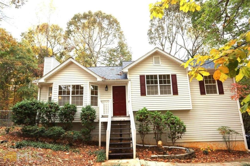 White siding exterior with a dark red entry door