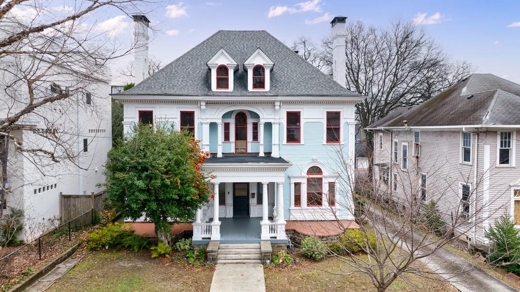 Chance of a Lifetime to experience living in this Stunning Victorian masterpiece, built in 1896 and on the National Registry, is located in the heart of Midtown's Historic District. Combining timeless elegance with modern comforts, this architectural treasure offers a unique opportunity to live in one of Atlanta's most iconic neighborhoods. Step inside to discover original hardwood floors, exquisite stained-glass windows, and intricate period details throughout. The home features six fireplaces, multiple clawfoot tubs, 12 foot ceilings, and chandeliers that add to its historic charm. A grand dining room, complete with a one-of-a-kind ceiling mural and original built-ins, seamlessly connects to the chef's kitchen, which boasts stone countertops, a Sub-Zero refrigerator, a wine fridge, and a cozy breakfast nook overlooking the sunroom. The sunroom, with retro checkerboard flooring, leads to a private deck and landscaped backyard perfect for entertaining, complete with a fire pit and basketball hoop. The main level offers flexible living spaces, including a formal study, parlor, and a versatile "Little Parlor" with its own full bathroom, perfect as a guest room or office. Upstairs, the primary suite features a sitting room, two fireplaces, and a luxurious spa-like bathroom with a soaking tub, double vanities, and a walk-in shower. Additional bedrooms are spacious and filled with natural light, while the third level provides a family living area ideal for relaxation or recreation. Located just steps from Piedmont Park, the Atlanta Beltline, and the Atlanta Botanical Garden, this home offers unparalleled access to Midtown's vibrant dining, arts, and outdoor amenities. Whether you're enjoying the nearby Fox Theatre, High Museum of Art, or Midtown's bustling festivals, this neighborhood delivers a dynamic and walkable lifestyle. For added convenience, the property includes a two-car garage, additional parking, and three separate rental units discreetly located in the rear triplex. Security cameras and exterior lighting provide extra peace of mind. If you're seeking the perfect blend of historic charm, modern luxury, and unbeatable location, this home is a must-see!