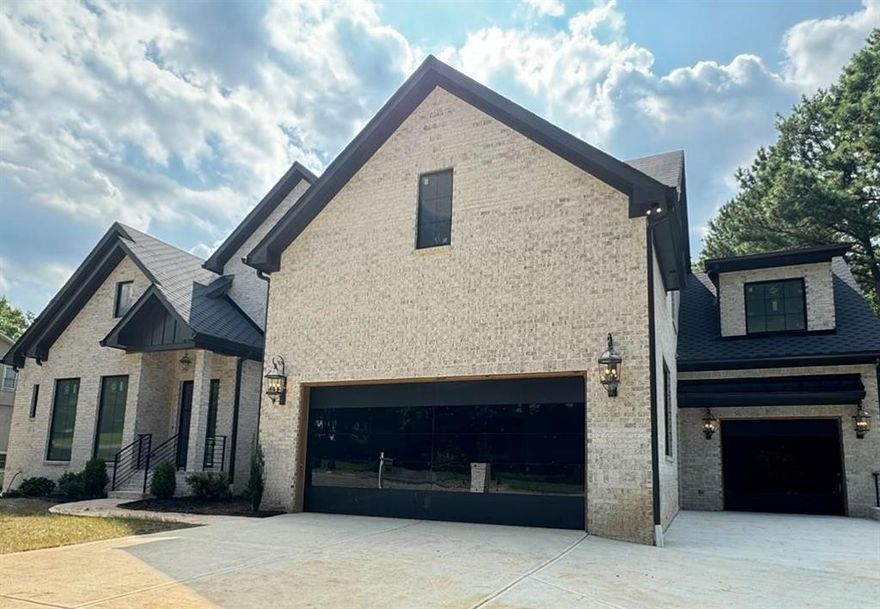 This exceptional new construction is an all-brick home featuring five spacious bedrooms, 5.5 bathrooms, and custom glass and steel 3-car garage doors. It offers two finished levels of luxury custom finishes with abundant natural light, complemented by an unfinished basement. This property is situated on a quiet street in the sought-after Walton High School district Indian Hills Country Club.
Step into a realm of sophistication where meticulous craftsmanship meets contemporary flair. The interior of this light-filled home boasts oversized windows that overlook a private backyard, perfect for a pool and outdoor living space. The open floor plan includes a state-of-the-art kitchen with a breakfast area, a family room, a formal dining room, a private office, and an oversized master suite on the main level. The master bedroom suite has a spa-style bath, and an expansive his and hers walk-in closet, providing a sanctuary of comfort and relaxation.
On the second level, you'll find an open space suitable for an additional living room, four large en-suite bedrooms, and a generously sized laundry room. The huge porch with a fireplace spans the back of the home, creating the perfect space for relaxing and enjoying outdoor privacy year-round. This home features four fireplaces, smart toilets, customized closets, Dry bar, 2 pantries, High-end appliances, Rope lights, high ceilings, custom cabinetry, handcrafted on-site, is complemented by pristine White Oak flooring. This home caters to every lifestyle need from its beautiful entrance to its extra-wide hallways, every detail has been thoughtfully designed to elevate your living experience. Whether hosting esteemed guests or enjoying family time, this residence seamlessly blends luxury and functionality.