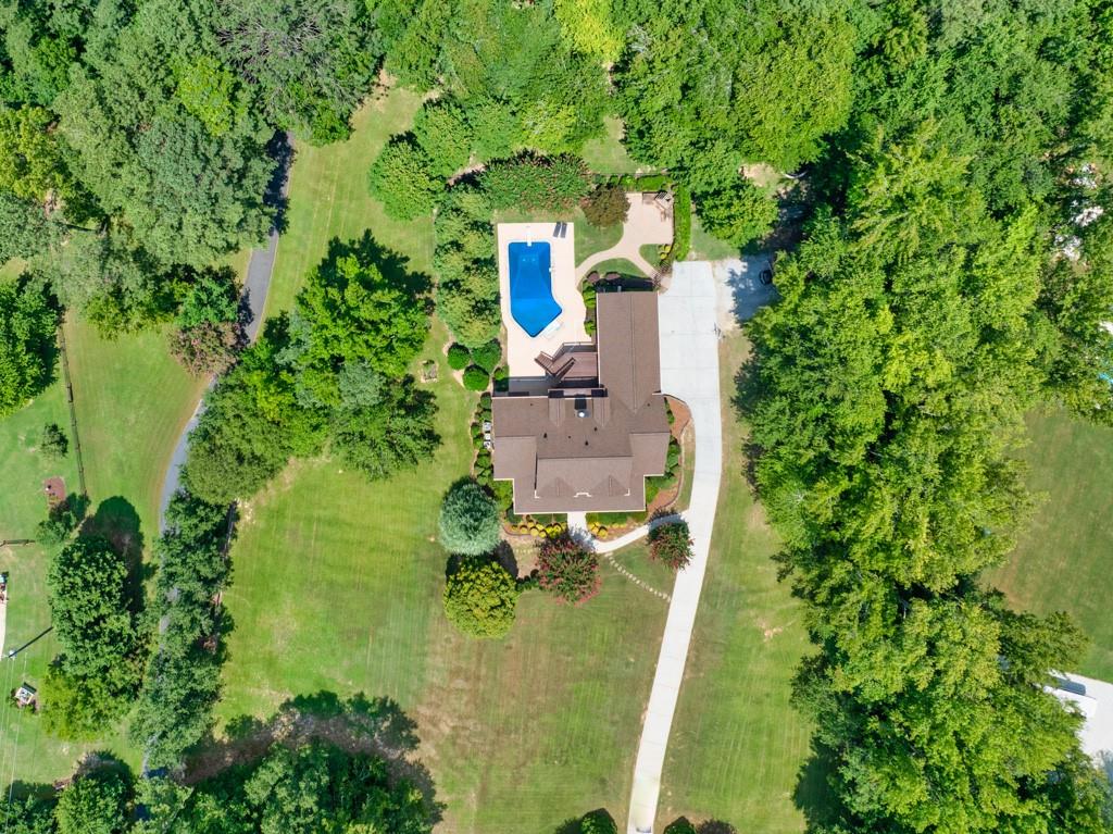 WELCOME HOME TO THIS CUSTOM-BUILT RESIDENCE, NESTLED ON OVER 5 ACRES OF LEVEL/WOODED PRIVACY WITH NEW ROOF. THE PRIMARY SUITE ON THE MAIN FLOOR OFFERS ELEGANCE AND COMFORT INCLUDING WALK IN CLOSET, HIS AND HER VANITIES AND SEPARATE TUB AND WALK IN SHOWER. THE RECENTLY RENOVATED KITCHEN FEATURES A HUGE ISLAND, ALONG WITH AMPLE CABINET AND COUNTERSPACE. HARDWOOD FLOORS RUN THROUGHOUT THE HOME ADDING WARMTH AND CHARACTER. DINING AREA IS OVERSIZED AND OFFICE AREA INCLUDES FRENCH DOORS FOR PRIVACY. THE UPPER LEVEL INCLUDES 5 SPACIOUS BEDROOMS, TWO BATHS AND JULIET BALCONY OVER LOOKING THE POOL AREA AND ESTATE. GUEST SUITE HAS PERFECT VIEW OF POOL, ACCESS TO DECK AND SEPARATE ENTRANCE. THE BASEMENT IS UNFINISHED READY FOR YOUR CUSTOM DESIGN. THE SALT WATER POOL, OUTDOOR FIREPLACE AREA AND PATIO ARE PERFECT FOR ENTERTAINING WITH PRIVACY GALORE.