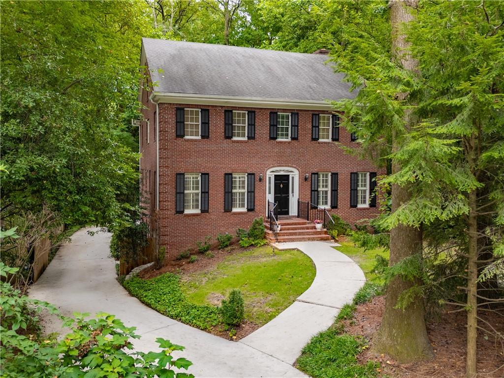 Exceptional, spacious 4BR/2.5BA four-sided brick home in coveted Parkwood neighborhood! Walk to Dancing Goats coffee, Toy Park, Chai Pani & Taqueria del Sol, plus East Lake MARTA for easy access to Mercedes-Benz Stadium & downtown Atlanta. Equidistant from vibrant downtown Decatur dining scene & trendy Oakhurst Village w/ sought-after CoD schools. Tight-knit, serene neighborhood where neighbors stay for generations hosting year-round gatherings - rare opportunity as only few homes sell annually! Stunning foyer w/ double glass doors leads to large LR w/ soaring wood beams & cozy gas FP flowing seamlessly to gourmet kitchen featuring 5-burner gas range, SS appliances, generous pantry, dedicated coffee bar & abundant storage perfect for entertaining. Formal DR accommodates dinner parties while eat-in kitchen opens to expansive deck overlooking private 0.45-acre wooded oasis - your own backyard retreat! Large office with built-ins perfect for remote work. Luxurious primary suite w/ tray ceiling overlooks established forest, featuring spa-like bath w/ custom walk-in closet, double vanity w/ storage, relaxing soaker tub & walk-in shower w/ dual heads. New hardwoods upstairs complement beautiful stained wood doors throughout. Three guest BRs share large hallway bath, one w/ dual closets & charming window seat. Convenient upstairs W/D hookups make family life easier. Finished basement transforms daily living w/ two large bonus rooms (new LVP flooring), one w/ fireplace - endless possibilities for home theater, gym, additional office, playroom or teen hangout - plus storage. Opportunity to add full bath downstairs. Spacious attic offers potential for additional finished square footage. Outdoor paradise features wooded backyard sanctuary perfect for morning coffee or evening beverage. Generous parking includes concrete pad ideal for basketball, games & outdoor fun, plus covered carport & 2-car garage w/ epoxy flooring. Recent premium updates: new high-grade HVAC systems, classic lighting throughout, crown molding, elegant plantation shutters. Every detail honors timeless architecture while meeting today's lifestyle demands. This isn't just a home - it's your gateway to the quintessential Decatur lifestyle where community, convenience & tranquility perfectly intersect!