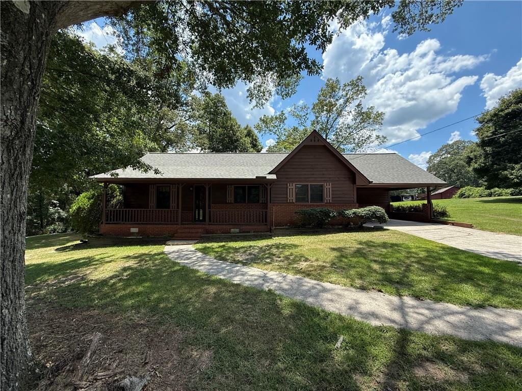 Discover the perfect blend of peaceful living and everyday convenience in this charming 2-bedroom, 1-bath home—easily adaptable to 3 bedrooms—nestled on over an acre in a desirable North Rockdale neighborhood. Just minutes from I-20 and the dining, shopping, and festivals of Old Town Conyers, this home offers the ideal location with a serene, country feel. Step inside to a spacious family room featuring a cozy brick hearth fireplace with a metal insert—perfect for cool nights. The large kitchen provides plenty of room for a dining table, abundant counter and cabinet space, and comes equipped with a brand-new oven and microwave. Central heating and air ensure year-round comfort, and a brand-new roof offers peace of mind. The oversized primary bedroom boasts a massive walk-in closet, while the flexible floor plan allows for a potential third bedroom or home office. Outside, enjoy the expansive yard, a patio perfect for relaxing or entertaining, and a handy outbuilding for storage or hobbies. The carport offers convenient covered parking and additional outdoor space. Come put your personal touch on this beautiful property and enjoy the best of Rockdale living—space, location, and charm all in one!