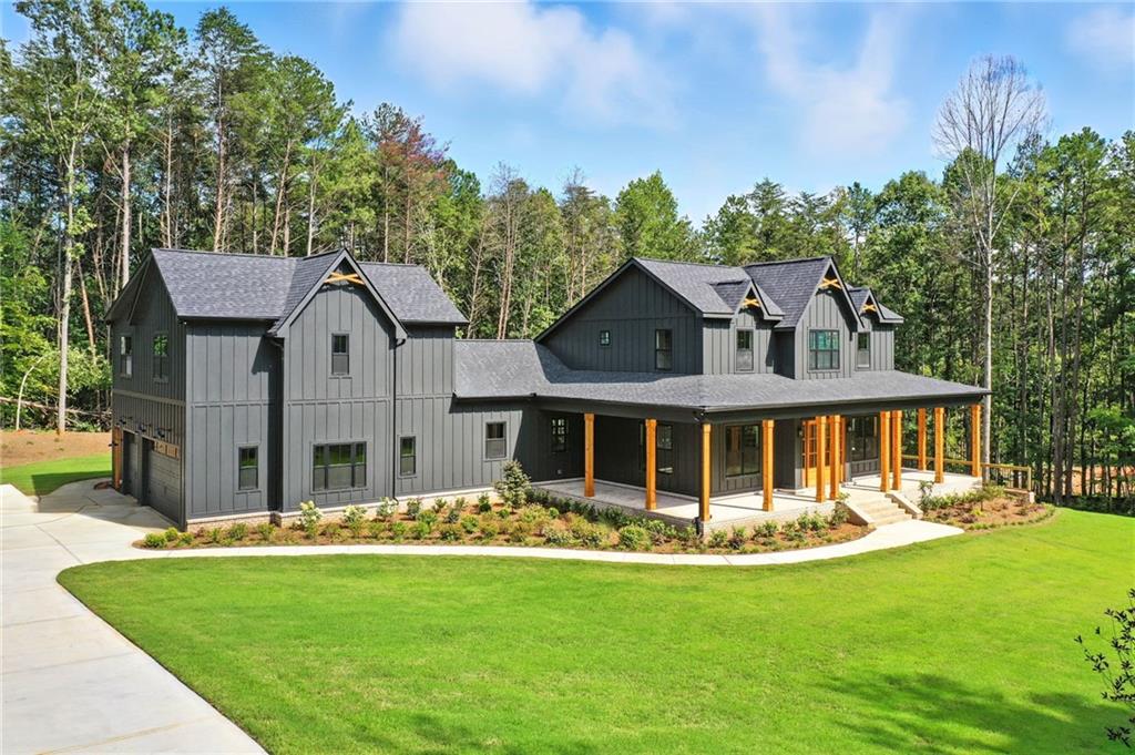 Exceptional New Construction Estate in The Highlands at Sharp Mountain with Seller offering to give $125,000 allowance toward inground pool!
Experience elevated living in this newly constructed almost 8,000 sq ft estate, where bespoke design meets refined elegance in one of North Georgia’s most exclusive gated communities. Set on 5 pristine acres within The Highlands at Sharp Mountain, this architectural showpiece commands attention with its striking black exterior, timeless brick accents, expansive covered front porch, rear veranda, and oversized three-car garage—a bold statement of modern sophistication.
Step inside to a light-filled, open-concept interior where wide-plank real white oak hardwoods lead you through a seamless flow of curated living spaces. The expansive family room anchors the heart of the home, while the chef’s kitchen impresses with Wolf and Sub-Zero appliances, custom cabinetry, a dramatic quartz island, and a fully equipped secondary prep kitchen, a bar hall with a wine and beverage cooler-designed for effortless entertaining.
The main-level owner's suite is a private sanctuary, featuring a spa-inspired bathroom and generous walk-in closets with seller offering a $10k allowance toward closets customization. An additional main-level guest suite with a full bath, along with a stylish powder room, offers comfort and convenience for visitors. A spacious laundry room connects to a secondary staircase that leads to a private guest suite above the garage, complete with its own full bath—ideal for multi-generational living or a private office.
Upstairs, two thoughtfully designed bedrooms each offer en-suite baths, providing a perfect blend of comfort and privacy. The full, unfinished terrace level—over 3,000 sq ft—invites endless possibilities, from a custom home theater or fitness center to a workshop or expanded storage. Some additional features are a Daikin Smart System for HVAC, as well as a Rinnai Tankless Water Heater!
Located within an intimate enclave of just 21 estate-sized homesites, this home offers a rare combination of seclusion and accessibility—just minutes from historic downtown Ball Ground, top-rated schools, I-575, Canton Marketplace, Northside Hospital, and the scenic beauty of the North Georgia mountains.
Luxury, privacy, and convenience—reimagined. Welcome home.