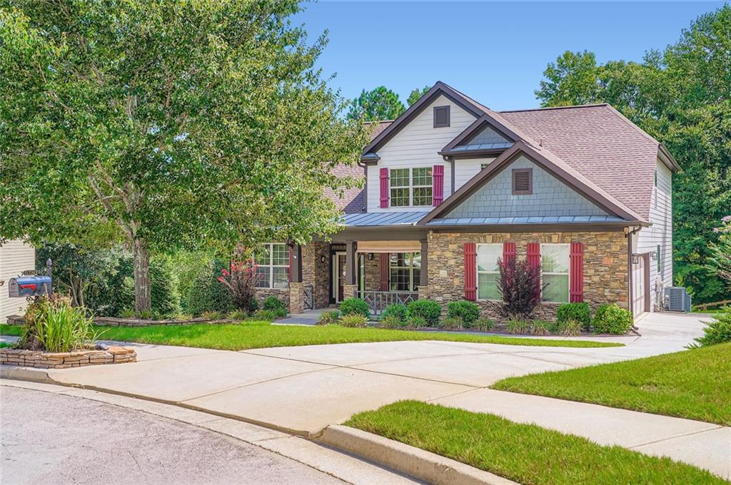 Welcome to this stunning gem in the desirable Grand Oaks Subdivision! This exquisite craftsman-style traditional home sits on nearly an acre of beautifully landscaped grounds. Inside, you'll find master on the main level, plus a spacious office adjacent to the two car garage, in addition to the enormous kitchen, great room, and separate dining room. The inviting breakfast room draws you to the rear egress that leads out to the main level deck, overlooking the giant backyard and wooded area at its rear. The upper level includes three large bedrooms and two full baths. Noteworthy upgrades include gleaming hardwood floors, sleek granite countertops, and custom trim accents. The massive basement includes a wonderful game room, a handy workshop, and its own full bedroom and bathroom perfect for hosting and full entertainment/relaxation. The walk out basement provides easy access to the private covered rear patio. A true opportunity in the lovely Flowery Branch, make sure you come and see this can't miss opportunity!!