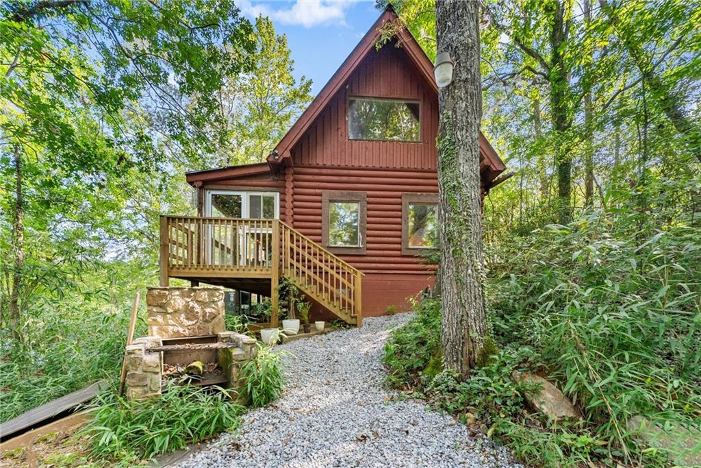 This beautiful lake house cabin sits on the Etowah River Watershed Lake, offering the ultimate in peace and seclusion. Featuring an open floor plan with gleaming hardwood floors and updated kitchen, this spacious home is perfect for vacation getaways or full-time living. Wake up to serene lake views from the oversized master suite, complete with its own private deck ideal for your morning coffee or quiet evenings under the stars. Step outside to enjoy the private dock and an entertainers dream deck with plenty of built-in seating, perfect for gatherings, fishing, or simply soaking in the natural beauty. Don't miss this rare opportunity to own a 5 acre piece of lakeside paradise in one of North Georgia's most charming towns. The current owner has an Assumable Mortgage that could potentially be a huge advantage for Buyer's that qualify.