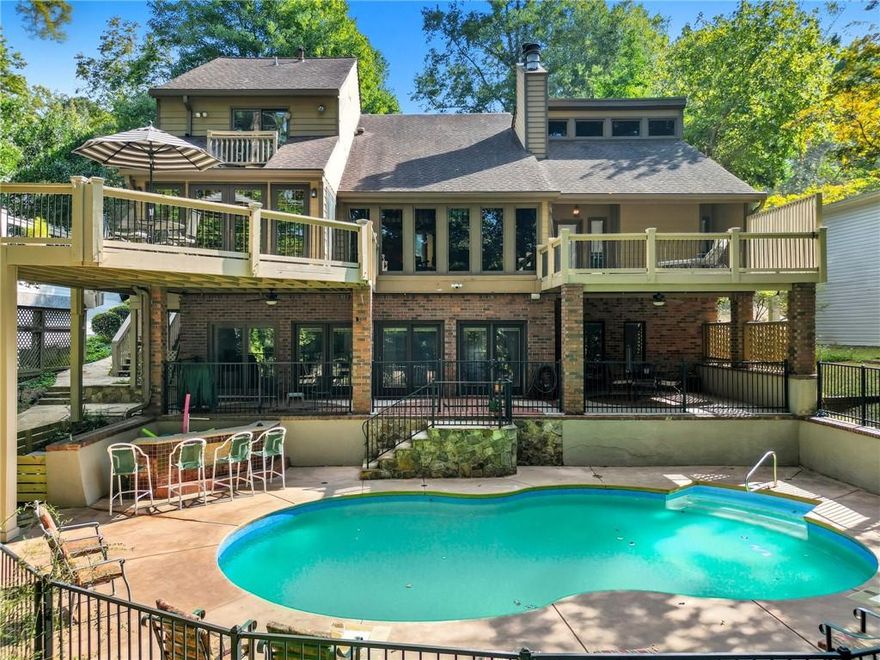 Looking for a lake view from almost every room?  Conveniently located near shopping, restaurants, and 5 minutes from GA 400.   5 BR, 4.5 BA, Finished Basement, Pool, and 30x30 2-slip/2-story.  DEEP water, PRIVATE party dock. 3 fireplaces. Primary Suite on the main with doors to the deck and a flagstone fireplace.  The two-story family room features a tongue-and-groove ceiling with beams and a wall of windows overlooking the pool and lake view.  Floor-to-ceiling flagstone fireplace. Top-rated schools. Fall in love with the heart of the home: the kitchen you’ve been waiting for. Open, bright, and thoughtfully designed, this chef’s kitchen overlooks the dining room. It’s truly the kitchen of your dreams—perfect for cooking, entertaining, and gathering with family and friends. The main floor features a spacious vaulted ceiling master suite, complete with a walk-in shower and soaking tub. Upstairs, you’ll find two additional bedrooms and one full bathroom.   A  finished basement offers a versatile blend of functional living space with a kitchen, living area, pool table, 2 bedrooms, and two bathrooms.  Step outside to your private pool and a beautifully landscaped backyard. An expansive flagstone patio and multiple decks are perfect for entertaining.   A covered eating area and custom stone details make this the perfect space for entertaining or relaxing. The gentle walk to the lake under mature trees provides both privacy and a serene natural setting. This home isn’t just a place to live—it’s a lifestyle. The garage offers a walk-up attic for storage.