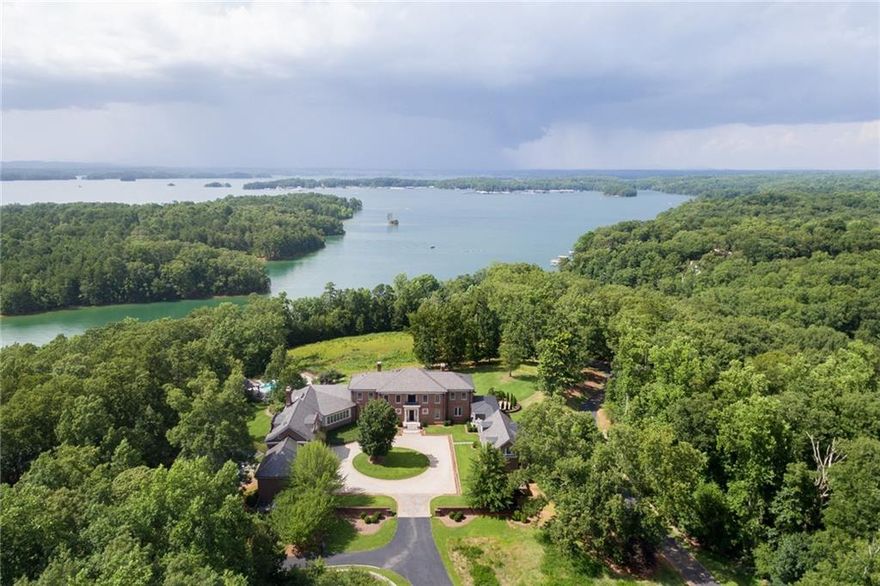 Elegant custom built home with gorgeous setting overlooking Lake Lanier. Imagine the privacy and views that this magnificent residence commands! The main house is complemented by an attached apartment above the garage as well as a two story guest house attached by a breezeway. High ceilings, beautiful architectural details, gorgeous hardwood floors, wonderful floor plan. There is a lot of land available surrounding this estate property so the acreage is negotiable - you really have to see it to decide! A truly special offering! There is a lot of water frontage available also but too hard to measure to include specifically at this point! Only a 40 minute drive from Atlanta which makes it great for a primary or secondary residence. Surrounding area is a wildlife preserve so will never be built on, adding even more privacy! Really amazing opportunity!