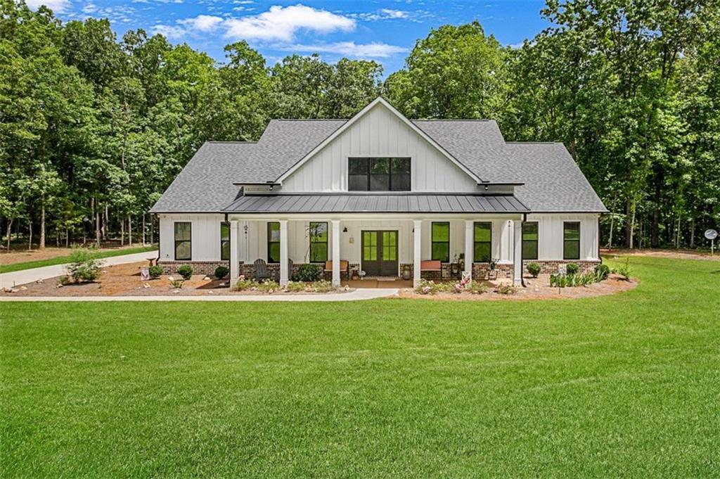 Completed in 2023, this stunning and immaculate 5-bedroom, 3-bath residence sitting on 5.3 acres offers a blend of luxury and functionality with countless high-end upgrades throughout. From the moment you travel down the gravel drive thru the serene views of trees all the way to the oversized front porch, you will realize just how private this home really is. Entering thru the lavishing french doors, you'll be greeted by stylish herringbone flooring that guides you into a bright, open living space designed with entertaining in mind. The seamless and open flow from the living area into the kitchen creates an inviting atmosphere, where granite countertops, a generous island, and abundant cabinetry make this chef's kitchen a dream for hosting gatherings. A separate dining room exhibits lots of natural light and the style you've been searching for. Step into the beautifully designed family room that effortlessly combines comfort, style, and functionality. A cozy brick fireplace with a crisp white mantle, with an electric fireplace that can be converted to gas logs concludes that this space is perfect for relaxing evenings or entertaining guests. Enjoy the warm ambiance created by the herringbone-patterned wood flooring and natural light pouring in through large windows with serene wooded views. A stunning windmill-style ceiling fan adds a unique focal point. With an open layout, modern finishes, and cozy character, this living area is the heart of the home. The main-level primary suite serves as a peaceful retreat, providing privacy and comfort. A thoughtfully designed split-bedroom layout ensures space and seclusion for both family members and guests. Let's not forget the bonus room with additional storage. Home also comes with a 3 car attached garage. Covered back deck is perfect for entertaining and just relaxing for morning coffee. Backyard is private with an abundance of trees and wildlife for you to enjoy. For those who enjoy hobbies or need extra storage, the property includes a spacious 3-bay workshop- 30x42 on concrete slab with power and would be ideal for tools, outdoor gear, or DIY projects. Craftsman-style charm meets natural beauty on this wooded lot, completely sodded offering a peaceful escape in a picturesque setting. With attention to detail and upscale finishes at every turn, this home has something for everyone. Home now has Fiber Optic Internet installed..Don't miss the chance to call this exceptional property your own!