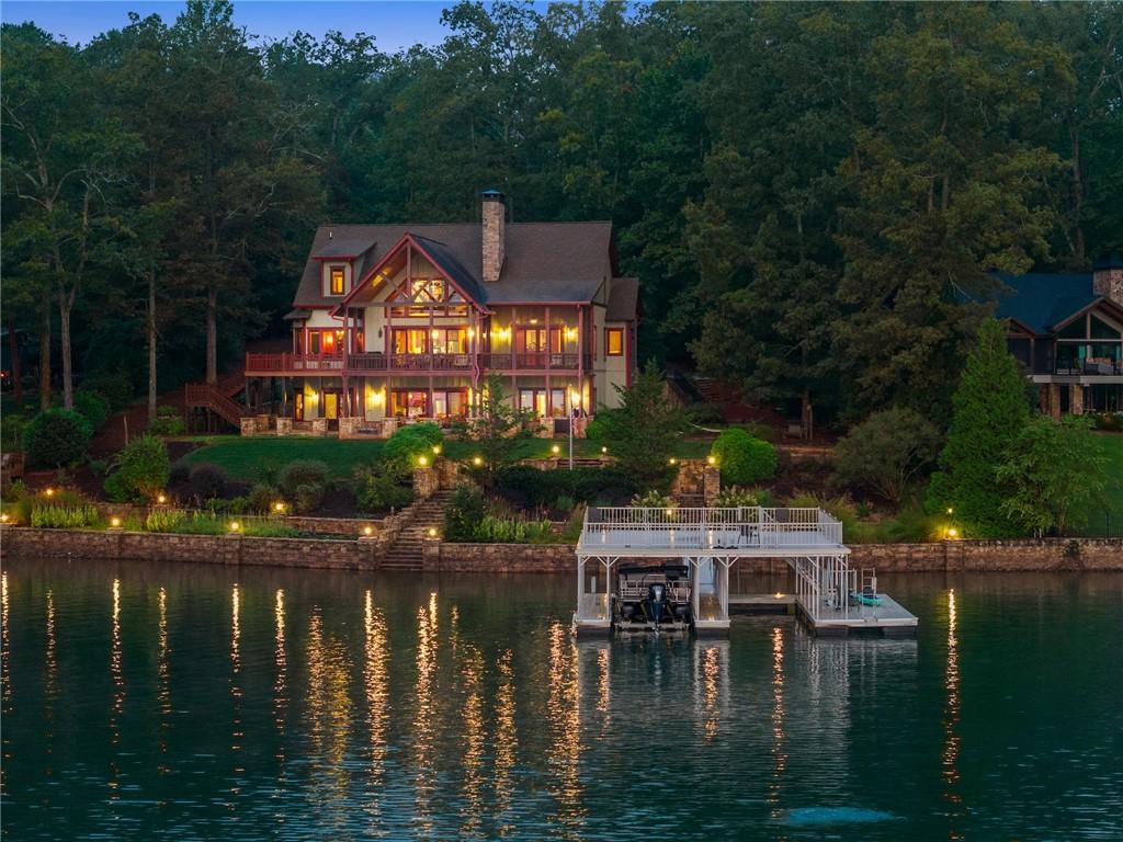 One of Lake Chatuge's Finest with all the features that make a Great Lake Home. Deep Water, Expansive Mountain Views, Large Dock, Amazing Home.
Discover lakefront living at its finest in this 5 bedroom, 5.5 bath custom Timberlake-built home on the pristine deep waters of Lake Chatuge, The Home offers breathtaking views of both the lake and Mountains. This masterpiece combines timeless craftsmanship, elegant design, and every luxury you could ask for in a Lake Home.
Main Level Features:
Spectacular Great Room with soaring ceilings, a dramatic stone fireplace, and massive windows framing unforgettable lake views
Gourmet Kitchen with premium finishes, high-end appliances, and a seamless flow into the dining area overlooking the lake
Stunning Master Suite with lake views, a private screened porch, spa-style bath, and walk-in closet
Dedicated office and laundry/mud room
Attached 2-car garage for easy access
Upstairs Retreat:
Private ensuite bedroom with full bath
Additional bedroom and bath
Loft area perfect for a lounge, library, or flex space
Generous storage options throughout
Terrace Level Entertaining:
Two additional ensuite bedrooms with full baths
Kitchenette/wet bar with refrigerator for hosting with ease
Cozy den with a stone fireplace
Workshop in Basement and plenty of organized storage
Outdoor Paradise:
Terraced stone walls & patios create multiple levels of outdoor enjoyment
Expansive cathedral-covered screened porch and large open decks totaling thousands of sq. ft. of outdoor living space — all with incredible lake and mountain views
Mature landscaping & irrigated yard to enhance the natural beauty of the lot
Top-of-the-line aluminum Double Slip covered dock with swim platform & party deck on year-round deep water
This home truly has it all: quality construction, abundant features, smart design, year-round water, and one of the best lakefront neighborhoods on Lake Chatuge.
Home Comes Fully Furnished and includes Dock and Boatlift.
