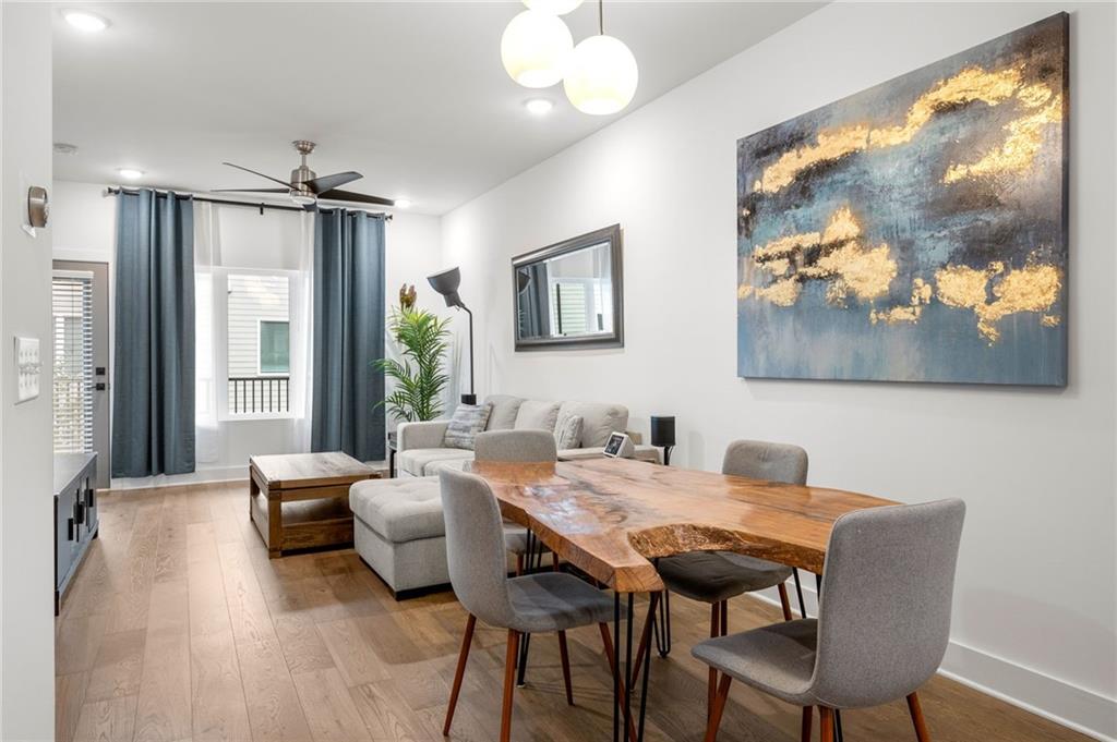 Effortless city living meets resort-style luxury in this Walker Park townhome, designed for the entertainer who loves modern, light-filled spaces. Across three levels, this home combines thoughtful design, high-end finishes, and lifestyle-friendly touches for the ultimate in contemporary comfort. The main level is a seamless blend of style and function, featuring an open-concept living, dining, and kitchen area flooded with natural light. The chef’s kitchen is a true centerpiece, with quartz countertops, a striking tiled backsplash, a five-burner range, convection oven, and stainless-steel appliances. Hardwood floors flow throughout, and the covered balcony off the living room is the perfect perch for morning coffee or evening unwinding. A powder room with bold blue walls and gold accents adds a sophisticated design touch. Upstairs, the primary suite is a private, resort-like retreat with its own balcony, striking accent wall, and en suite bath featuring a frameless glass shower with rain showerhead and double vanity. A second bedroom with a full bath ensures comfort and privacy for guests or family. The lower level includes a versatile bedroom with en suite bath, ideal for a home office, gym, studio, or guest suite. A one-car garage adds privacy and convenience, while high-efficiency appliances, HVAC, and water heater, along with sound insulation throughout, make this home energy and sound efficient. Lifestyle and location converge effortlessly. Just a two-minute walk brings you to Pure Quill Superette and El Tesoro, two of Atlanta’s most celebrated restaurants. Across the street, Walker Park offers a running track, playground, dog park, and expansive field, with Coan Park also nearby. Savor mornings and afternoons on your porch, enhanced with custom shades for sun or privacy. With spaces made for living, entertaining, and enjoying every Atlanta moment, this Walker Park townhome defines modern city luxury.