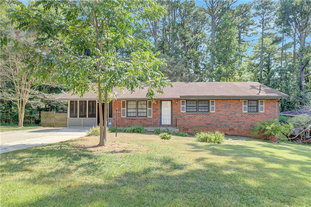 Welcome home to this 3-bedroom 1.5-bathroom midcentury brick ranch nestled on a private lot with an extra wide driveway/parking pad that wraps around to a private fenced backyard. Inside you'll find original hardwood flooring throughout the living room, dining room and bedrooms. The tiled kitchen offers plenty of cabinet space as well as granite countertops and access to the patio in the backyard. The hall brings you to two bedrooms that share a full hall bath as well as a primary bedroom with ensuite half bathroom, complete with charming original midcentury tile! Separate laundry room can be found inside the screened porch off the kitchen . . . outdoor living space to sit back and enjoy this quiet neighborhood only minutes from East Atlanta Village, I-20 and 285. There is an unfinished basement accessible from the exterior that offers 600+ sf of storage space as well. With a few updates here and there, this home will have it all!