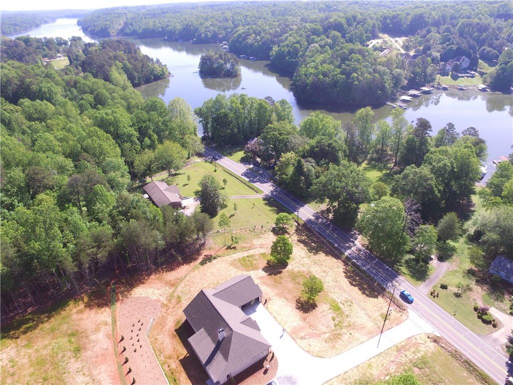 THIS IS IT! Brand new custom-built construction on 2.9 acres complete and ready to make your own! Stepless ranch only minutes from GA Heart Center, hospital, medical offices, grocery, restaurants and Lake Lanier with NO HOA! Three bedrooms + designated office. The gorgeous chef's kitchen features shaker & glass cabinets, massive island, gleaming quartz countertops, tile backsplash. hardwood floors and sun-filled windows. Large, open kitchen, living & dining room opening to covered outdoor living space with another cozy fireplace. Coastal vibe with beautiful beamed ceilings, handsome lighting, lite flooring and charming feature walls. Spacious primary suite with his/her closets & vanities, free-standing tub, and stylish shower. Oversized 30x30 garage, made to fit long boats and trucks, and additional door in rear of garage for lawn mowers and toys. Huge parking area for RV, boats and more! Minutes from Lanier Canoe & Kayak Club. MUST SEE!