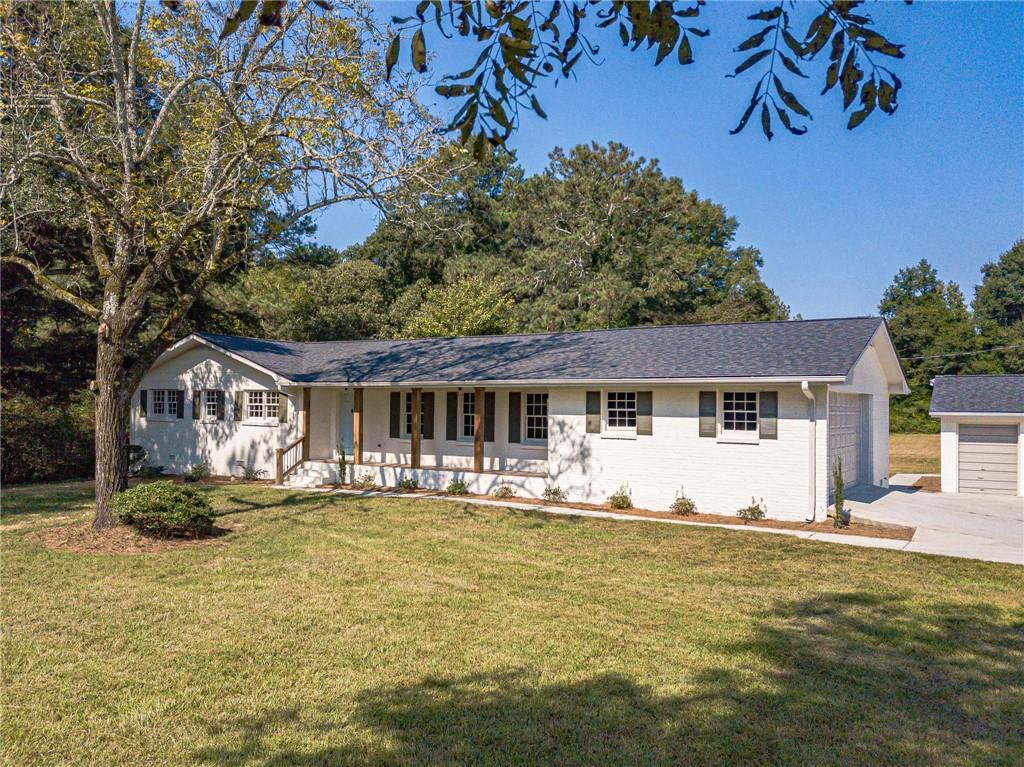 5.5% or Lower Interest Rate for Year 1 with Preferred Lender! Welcome to your peaceful retreat on 2 level acres in the sought-after Loganville school district! This beautifully updated ranch home offers 3 bedrooms, 2.5 baths with an open, inviting floor plan plus a detached garage/workshop. Step inside to find a bright and airy living space centered around a cozy fireplace. The designer kitchen features crisp white cabinetry, granite countertops, stainless steel appliances, a custom vent hood, and walk-in pantry. The primary suite is a true escape with a walk-in closet, dual vanity, and a spa-inspired tiled shower. Two additional bedrooms share a stylish full bath, and there is a convenient half bath ideal for guests. Every detail is NEW roof, septic lines, water heater, flooring, cabinetry, granite, appliances, plumbing fixtures, lighting, garage door, interior/exterior paint, and more giving you total peace of mind. For those who need space to work or play, the home offers both an attached garage and a detached 3-bay garage/workshop. Outside, relax or entertain under the covered patio or enjoy the wide-open yard perfect for putting in your own pool! With serene surroundings just minutes from Loganville's conveniences, this move-in ready home truly has it all!