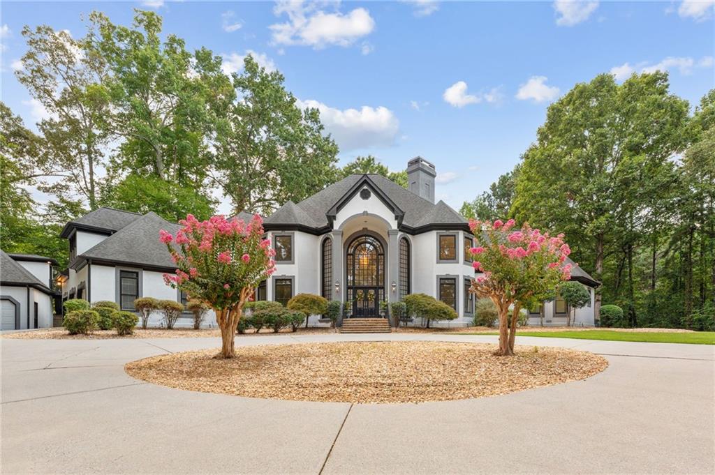 Welcome to Fairway Estates, one of the most prestigious gated enclaves in the heart of horse country. As you approach the stately entrance, you’re greeted by twin fountains, towering brickwork, and ornate wrought-iron gates—a breathtaking prelude to the elegance that awaits within.
Nestled on 3.99 manicured acres along a private lake, this estate captivates at first glance. A sweeping front lawn rolls down to the water’s edge, setting a scene of serenity and grandeur. Beyond the gates, a magnificent carriage house with three-car garage and private studio apartment stands proudly, while the main residence offers an additional three garages—six in total—ideal for a discerning collector.
The approach is nothing short of cinematic: flagstone steps ascend to soaring two-story arched windows, hinting at the grandeur within. Step inside, and you are welcomed by a spiraling staircase, gleaming marble floors, and a freshly refreshed interior designed for both intimate gatherings and large-scale entertaining.
The formal living room, anchored by a fireplace and full bar, is framed in walls of glass, blurring the line between indoors and out. This space flows effortlessly into a sun-drenched sitting area and expansive kitchen, where sleek new quartz countertops and several prep areas make culinary pursuits a joy. A grand dining room and spacious laundry complete the main living areas.
The primary suite is a sanctuary unto itself: an oversized bedroom, private office with spiral stair to an exercise room, dual walk-in closets with built-in safes, and a spa-inspired bathroom. Columns frame a luxurious soaking tub, while a dual-head shower and adjoining spa room with illuminated arched ceiling elevate the experience to resort quality.
Upstairs, the residence transforms into an entertainer’s paradise. Three ensuite bedrooms, a grand media room, and an impressive sunken pool room with mirrored shelving create endless opportunities for gathering and celebration.
Guests enjoy the utmost privacy in the detached studio above the carriage house, while the backyard invites leisure with its resort-style pool, winding flagstone paths, and multiple terraces overlooking the tranquil lake. The potential buyer will be excited to bring their pool designer to make this portion of the property with their own style stamp.
This is more than a home—it is a statement of refinement, a retreat of rare beauty, and an entertainer’s dream, all within one of the region’s most coveted addresses.PROFESSIONAL PHOTOS TO COME IMMEDIATELY!