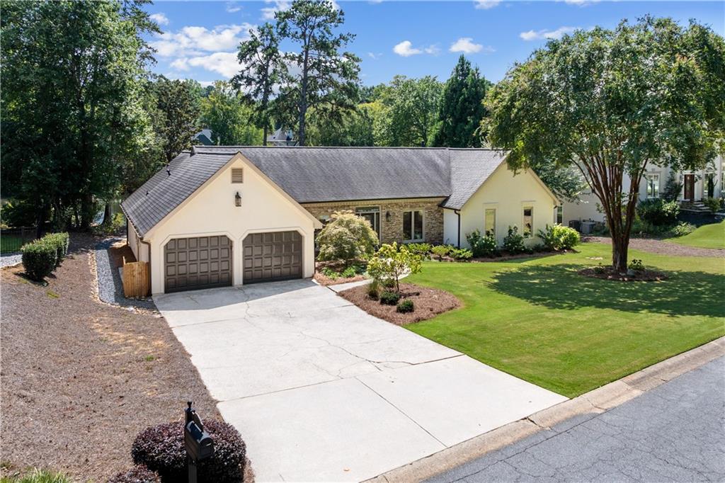 Rare lakeside living right in East Cobb! Enjoy lake views from nearly every window in this beautifully maintained home, ideally located just a short walk to top-ranked Walton High School, the neighborhood pool, clubhouse, tennis, and pickleball courts. Blending modern updates with timeless charm, this home is truly move-in ready. Step inside to discover newly refinished hardwood floors throughout the house, soaring vaulted ceilings with rich wood accents, and oversized windows that frame breathtaking views of the lake. The open-floor concept family room features a gorgeous stacked stone fireplace and built-in cabinets and bookshelves. The kitchen boasts crisp white shaker cabinets, stainless steel appliances (refrigerator will remain), and granite countertops, flowing seamlessly into the main living areas . Relax with your morning coffee overlooking the lake from a bright, beautiful sunroom with double French doors leading to the backyard, new tile flooring, and modern paint colors. The spacious primary suite features more stunning lake views, patio/covered deck access, walk-in closet with built in closet system, and a spa-inspired bath with a soaking tub, separate shower, and dual vanity. The home upgrades include new interior and exterior lighting, family room and bedroom fans, all new window blinds with automated window blinds in the family room and sunroom. Freshly painted interior and exterior, and the yard is professionally landscaped. Outdoors, enjoy multiple gathering spaces designed for year-round enjoyment: a covered back deck, a patio, a firepit area, and a flat, grassy yard ideal for play. Enjoy the lake from your own dock with the pedal-boat and kayaks (that will remain). The community is architecturally controlled, ensuring a clean and cohesive streetscape. Don’t miss the chance to own this unique lakefront retreat in the heart of East Cobb—schedule your private tour today. Preferred closing attorney is Thomas & Brown/Ga First Title JV.