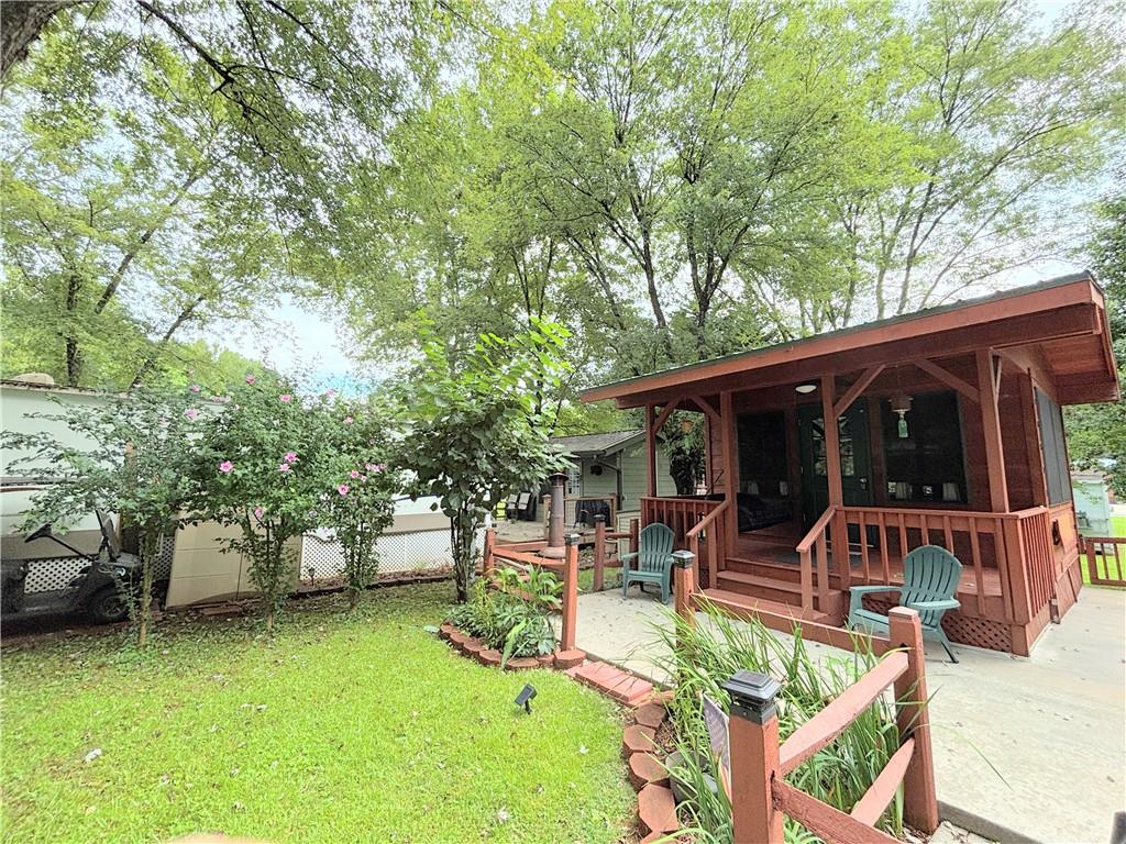 Looking for a little piece of Paradise to enjoy the N. Ga. Mountains, or just to park your RV? Come see this studio-style cabin! This stick-built cabin features a 14-foot-long front porch with a wicker swing, perfect for sitting and enjoying the quiet serenity on Fishtail Circle. The double-wide driveway will accommodate a larger RV, has a large concrete pad, fresh gravel drive, and can still fit 4 plus vehicles! There are nice shade trees surrounding the cabin and a grilling deck with bench seats perfect for entertaining. Inside are ceramic tile floors, wood walls, and a vaulted wood ceiling with a fan. All furnishings stay - such as the daybed couch with under storage, built-in end tables, table, four stools, and a corner cabinet, plus a vaulted storage area. You'll create a lifetime of memories here, whether you're relaxing, fishing, or participating in the ongoing activities within Paradise, a gated community with fantastic amenities! Enjoy the pool, pavilion, clubhouse, and planned activities. The location is central to all the fun in nearby mountain towns and events, just minutes from Cleveland, Helen, Dahlonega, Clarkesville, and Blairsville. Shop, dine, fish, hike, and visit vineyards-the possibilities are endless! Please note that Paradise is a vacation resort community that does not allow full-time living. The listing agents are owners in Paradise, so feel free to call for a tour or more detailed information about Paradise and this property.