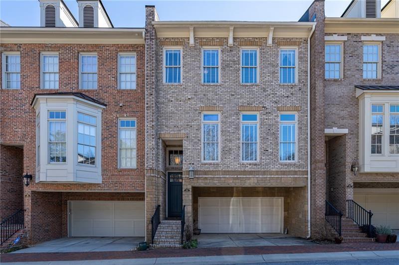 This elegant three-story brick townhome is ideally situated in Decatur, steps to Glenlake Park and the energetic Decatur Square. Enjoy the warmth of a freshly painted interior from the moment you arrive. The residence features three bedrooms and three and a half bathrooms, with hardwood floors and detailed moldings throughout the main living areas, and tile flooring on the terrace level. On the main level, you'll find a versatile living room that can serve as an office or playroom, a separate dining room, a powder room, and two closets for additional storage. The open kitchen, boasts a spacious island, high-end Viking appliances—including a six-burner gas cooktop, oven, and microwave—a Bosch dishwasher, ample cabinetry with custom pull-out drawers, granite countertops, and a walk-in pantry. An adjacent eat-in area overlooks the family room, which includes built-in shelving, a coffered ceiling, and a gas fireplace. A private deck extends from this space, providing a tranquil outdoor retreat. The upper level hosts a generous primary suite, complete with a bathroom that offers a separate tub, a glass walk-in shower with a tiled bench, and a double vanity with granite countertops. A dedicated laundry room equipped with cabinets and an additional closet is conveniently located in the hallway. The secondary bedroom suite on this floor is spacious, featuring a large walk-in closet and an updated bathroom with a granite vanity. The terrace level adds flexibility to the home, presenting a third bedroom with a full ensuite bathroom and access to a walk-out patio—ideal for guests or as a home office or den. The garage includes a substantial storage closet and opens into a mudroom on the terrace level, outfitted with custom cabinets for great storage. This townhome has been thoughtfully upgraded and offers abundant storage throughout. Its prime location allows for easy walks to a variety of restaurants and shops in Downtown Decatur and provides close proximity to the CDC, Emory University, downtown Atlanta, and more.