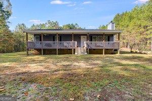 Welcome to your dream retreat! This adorable ranch is nestled on 32 acres of stunning natural beauty, primarily featuring hardwoods and pines. The property boasts a serene spring-fed lake, perfect for fishing and surrounded by abundant wildlife, including deer and wild turkey. Enjoy outdoor adventures with stationary deer stands offering 360-degree views, shooting lanes, and an array of walking and ATV trails. The charming "She Shed" with its inviting porch, a tool shed, and a camper/boat shed provide ample space for your hobbies and storage. The detached 2-car garage and fenced garden area add to the functionality of this beautiful property, complete with a fenced chicken pen. As you approach along the private long drive, you'll be greeted by mature Granny Smith apple and Keifer pear trees, along with flourishing blueberry bushes. Inside, the 1344 sq ft home is fully electric and designed for comfort, featuring the largest fireplace possible, currently equipped with gas logs but designed for wood burning. The expansive front porch runs the length of the house, supported by an extra beam for the perfect porch swing. Step inside to discover exquisite red oak flooring, granite countertops in the kitchen and baths, and natural cherry cabinets outfitted with soft-close doors and drawers. The spacious layout includes a luxurious 6-foot soaking tub, a generous pantry/laundry area with etched glass doors, and an abundance of floor-to-ceiling storage shelving. With R-13 insulation in the walls and R-30 in the ceiling, your home will be cozy year-round. This private location is not only a peaceful sanctuary but also offers a chance for income with mature pines ready for harvest. Don't miss the opportunity to make this remarkable property your own!