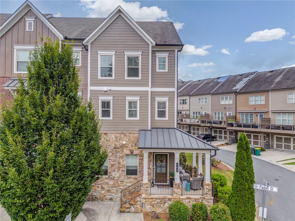 Welcome to Luxury Lifestyle Living in the heart of Downtown Woodstock this end unit at 28 And Mill is only a block from main street! This upscale townhome features 3 well appointed levels, offering about 2,143 sq ft of thoughtfully designed living space. It includes a 2 car rear entry garage and a covered front porch- ideal for greeting neighbors and guests the rear deck is perfect for relaxing or entertaining. Upgrades include but are not limited to wood accented walls creating a modern aesthetic thick rich textures that elevate the entire space. The kitchen flows into the dinning area - then to the living room. High ceilings oversized window, crisp trim detailing amplify the airy open feel. Gourmet kitchen is a delight to the chef in your family with the oversized island extra cabinets and counter tops - double ovens make cooking a breeze! The pantry-laundry-all closets have solid wood shelving built for serious storage. Roommate floor plan with the lower level having a bedroom with a full bathroom suite. Attic plus above garage you will find extra storage space. This home is unapologetically stylish every surface is refined not your ordinary home. This is the kind of home that whispers I know what I'm doing and shouts make an OFFER!!! Perfect for the smart classy functional mind set with ZERO fluff!