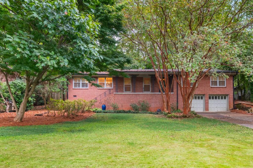 Tucked away on a quiet, tree-lined street, this stylishly remodeled mid-century home offers the perfect blend of modern updates and timeless charm. With spacious indoor and outdoor living across two levels, you'll love calling this place home. The stunning kitchen is a showstopper - featuring a mile of granite countertops throughout, a dramatic waterfall-edge island, a ton of prep space for holiday meals, and brand-new stainless steel appliances. Enjoy your morning coffee at the breakfast bar or in the cozy eat-in kitchen. The main level features four bedrooms, including two luxurious primary suites - ideal for guests, multigenerational living, or a dedicated home office. Step out to the screened-in porch for year-round enjoyment and views of the expansive, private backyard - perfect for gardening, entertaining, or simply relaxing. Downstairs, the terrace level boasts a massive family room with built-in shelving - easily large enough to divide into multiple spaces or add an additional bedroom. A spacious two-car garage provides abundant storage. This move-in-ready home combines comfort, space, and location - just minutes from Emory, the CDC, and three parks.