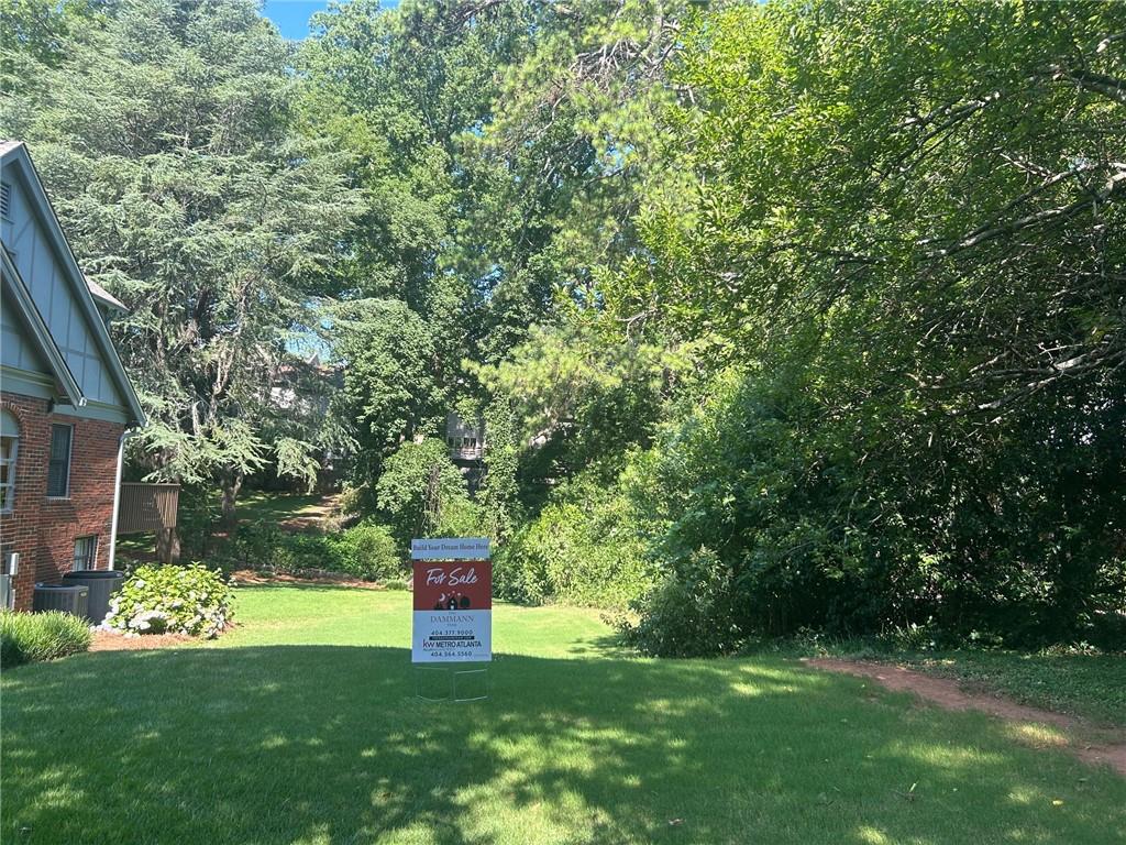 View of grassy yard with view of scattered trees